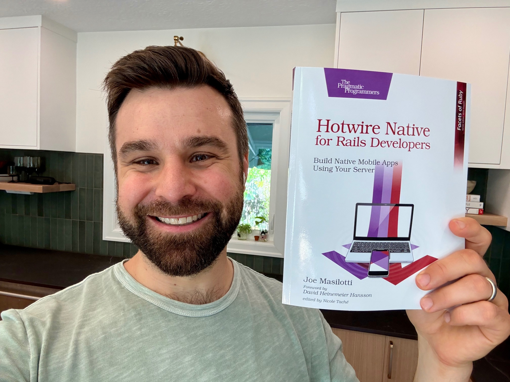 Joe Masilotti holding up a copy of his book, in print, "Hotwire Native for Rails Developers".