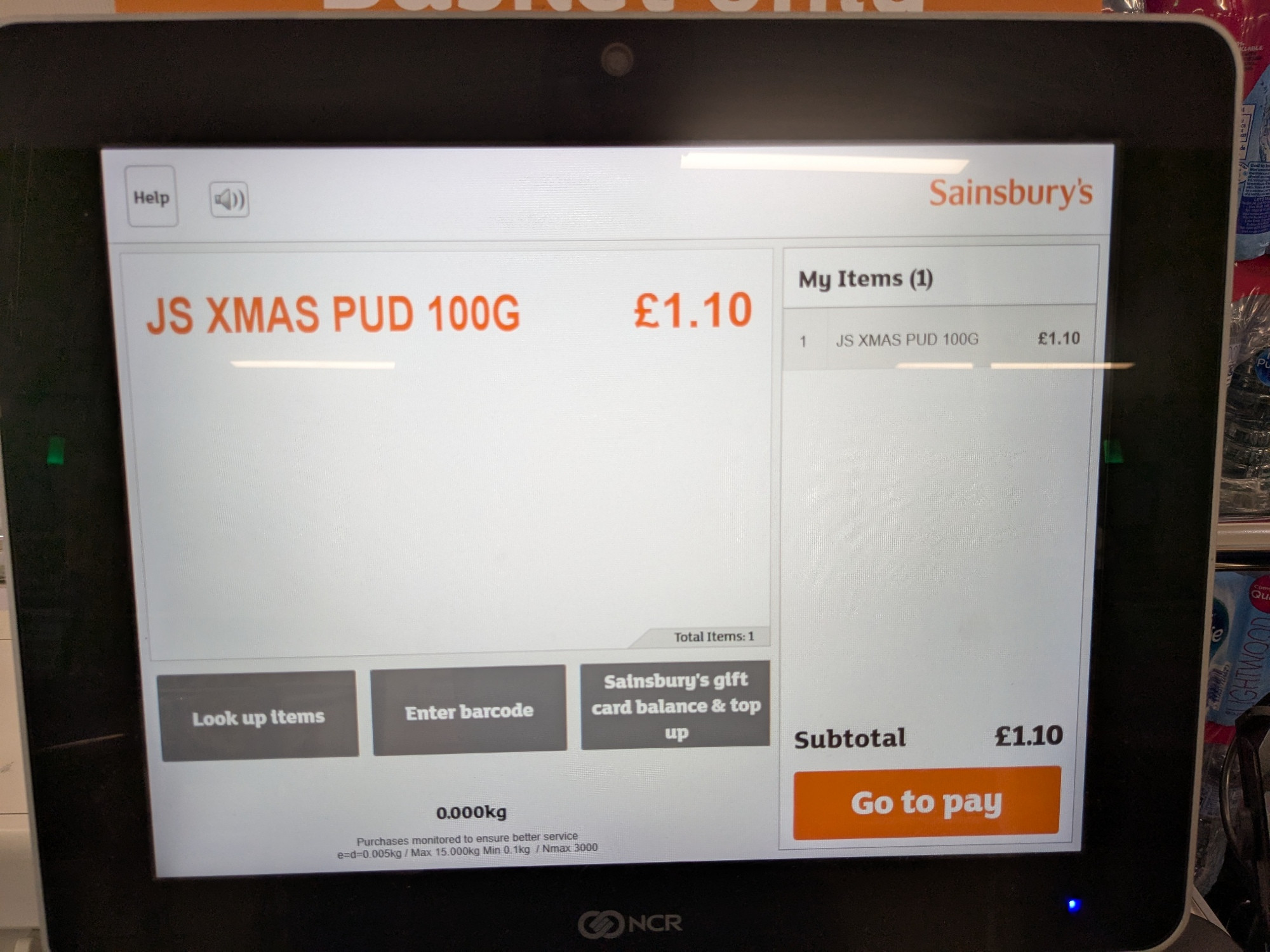 The screen of a self service checkout in a branch of Sainsbury's, showing one item, a 100g Xmas Pud, being purchased for £1.10.