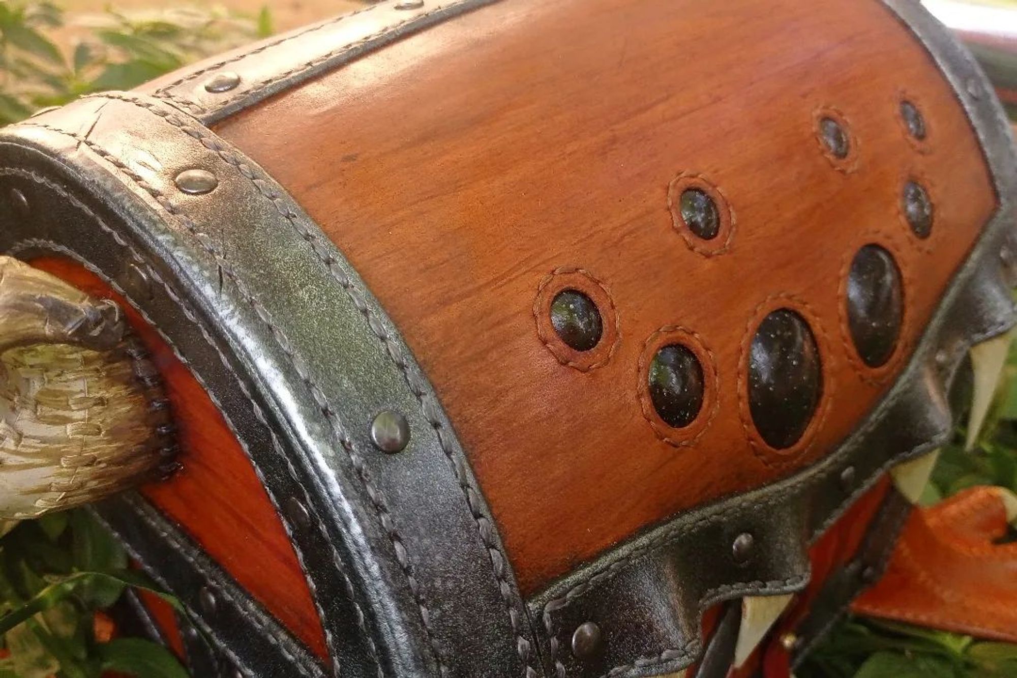 Detail pic of the lid: the wood grain simulated through strokes with the dyes, the glow finishing in the eyes, the painting and stitches following the direction of the strokes in the horns, the metallic effect in the reinforce metal bands...