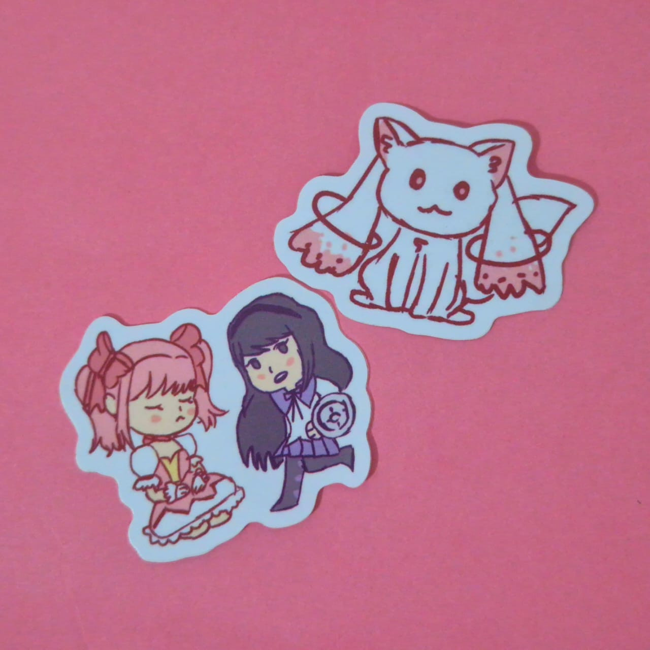 adesivos de vinil de puella magi madoka magica em um fundo de cartolina rosa, Os personagens chibi são madoka, homura e kyubey