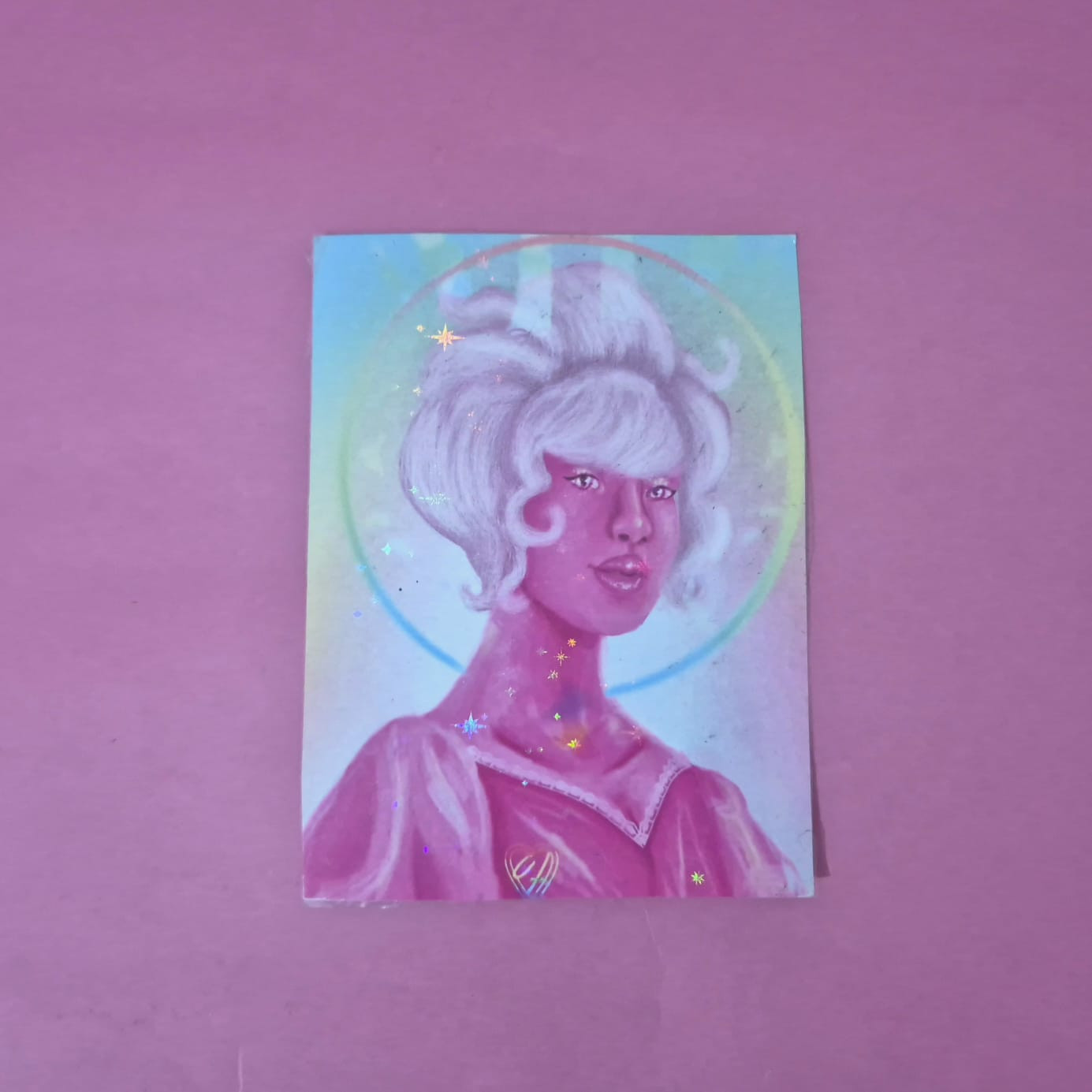 print postal retrato da personagem diamante rosa de steven universo, a arte tem tons fortes de rosa com um halo atras dela em tons de azul e verde, o fundo é um gradiente das mesmas cores. O print tem um brilho holográfico de estrelas pequenas.