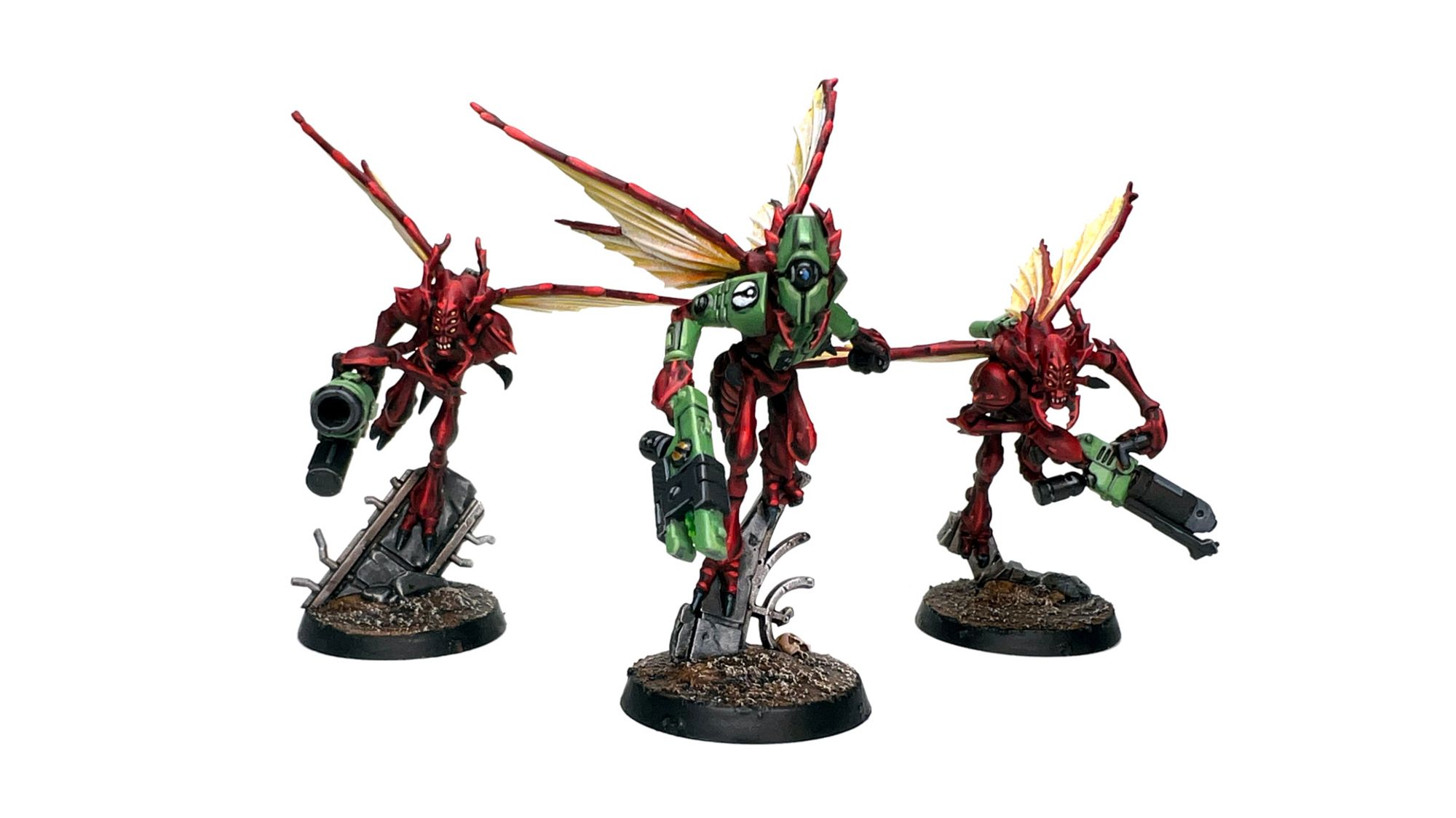 Three Vespid, painted red, with yellow wings and green wargear. A Skyblast wielding a grenade launcher is on the left, a Swarmguard with a flamer is on the right, and in the center is the Shadestrain with stealth gear.