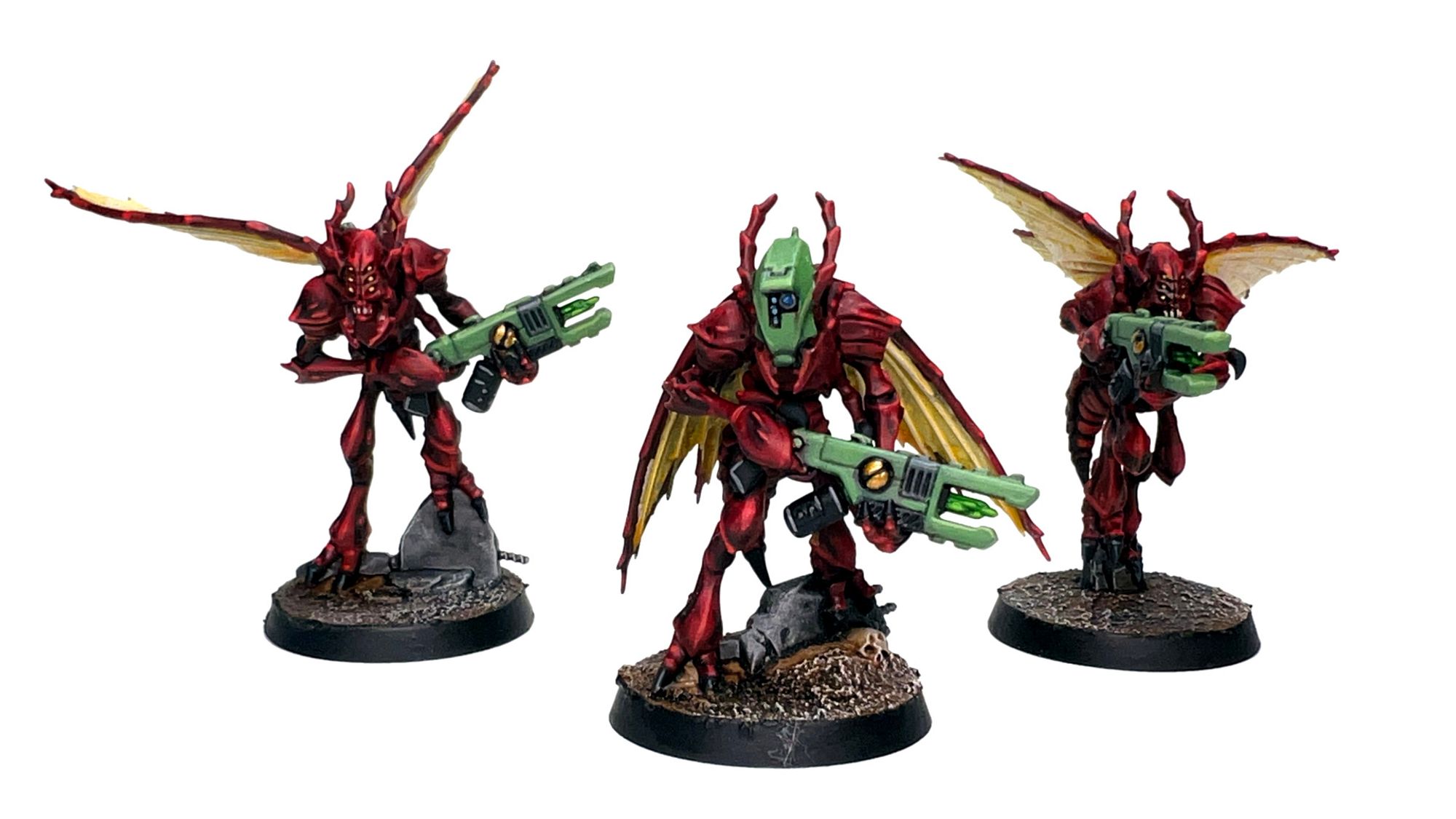 Three Vespid, painted red with yellow wings and green wargear. The Strain Leader, wearing a Communion Helm, is in the center, flanked by two Stingwings.