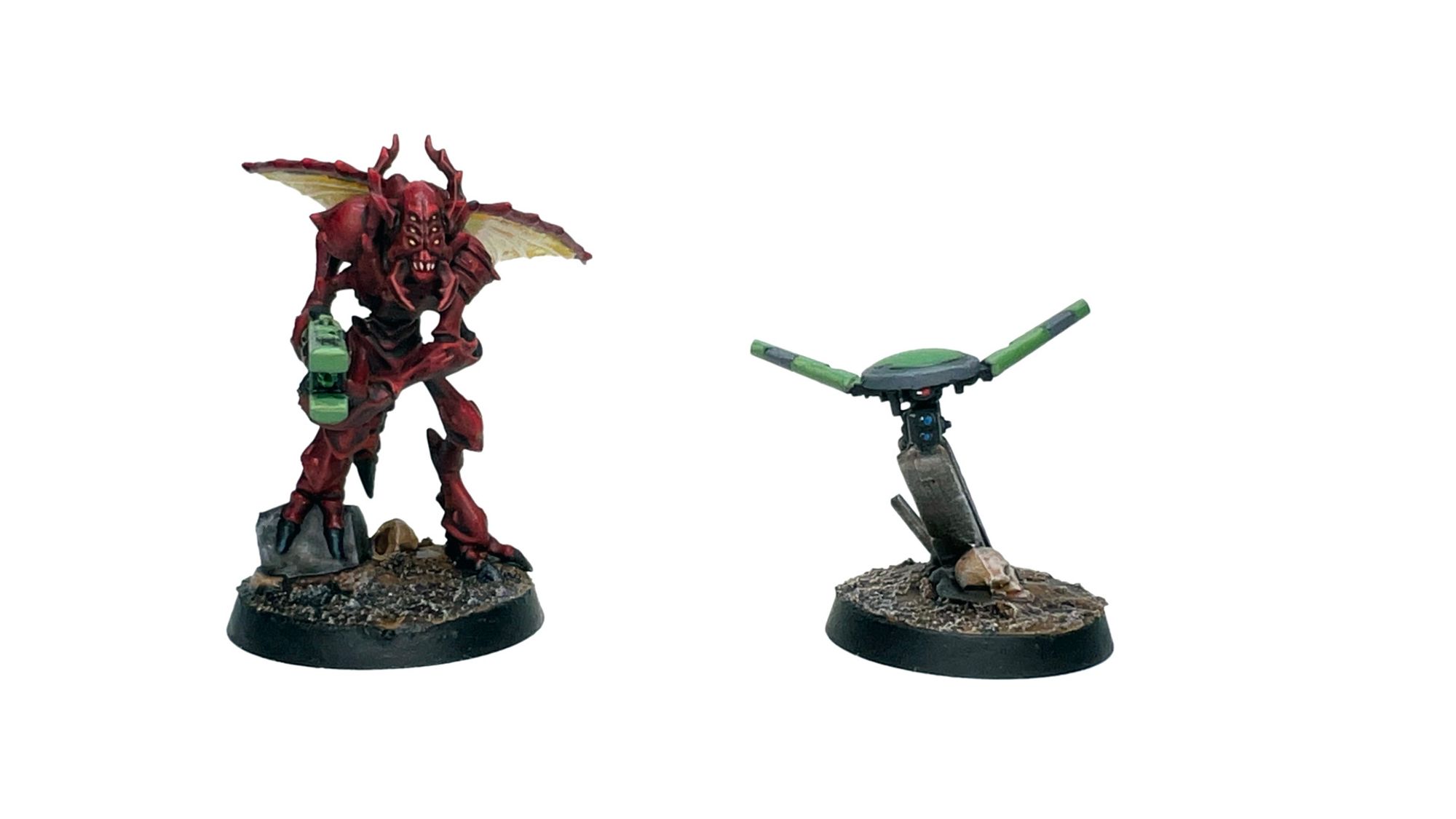 One Vespid, painted red, with yellow wings and green wargear. To its right is a green and grey Oversight Drone with red and blue eye lenses.