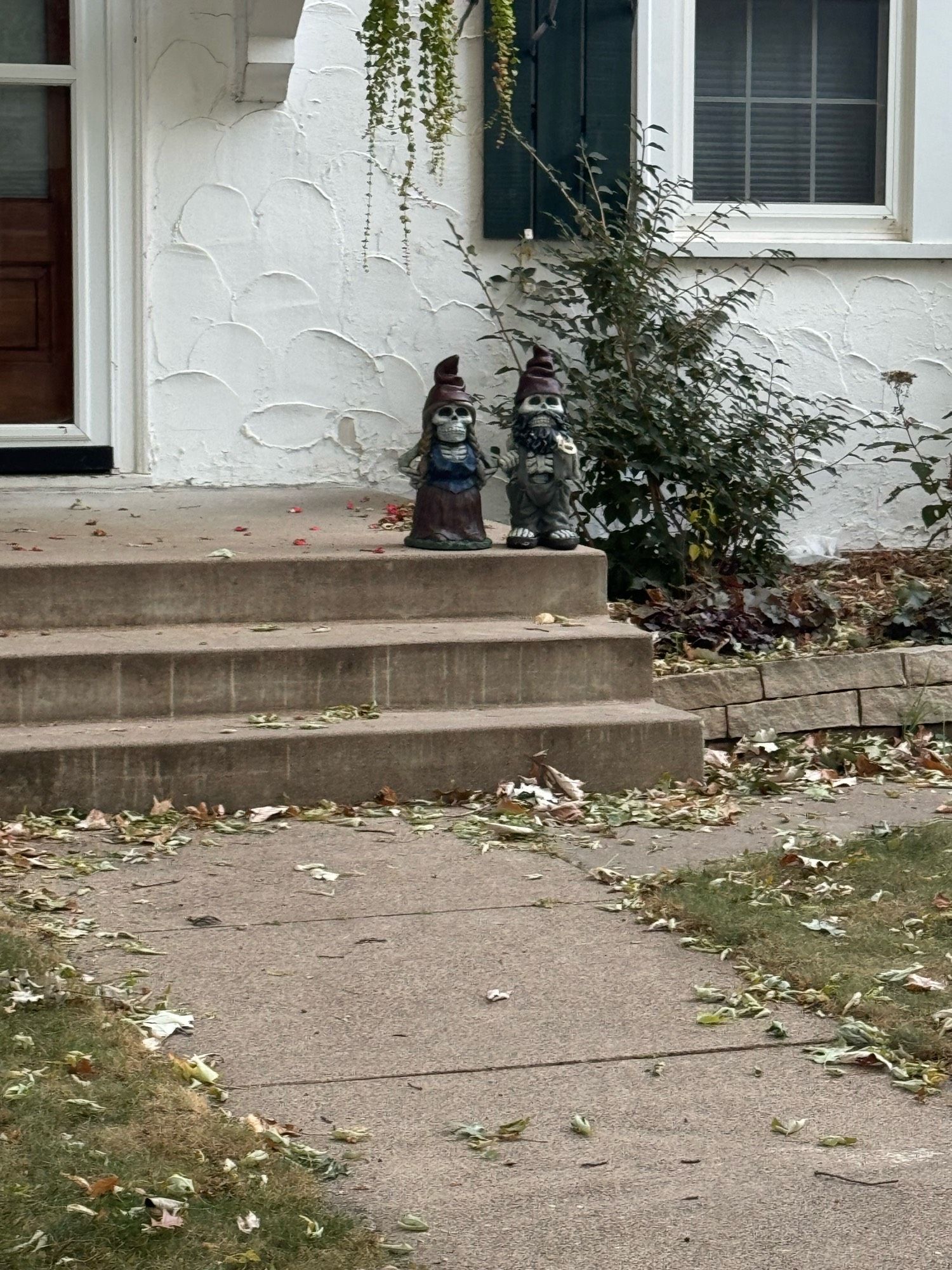 Gnome ornaments on front steps, but they’re skeleton gnomes