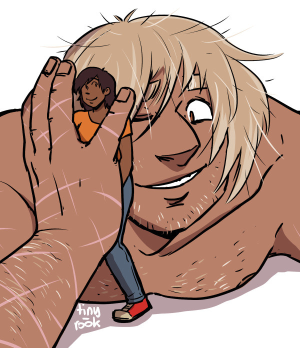 A blonde, tan male giant is pressing a dark skinned woman to his face with one hand. Both are smiling.