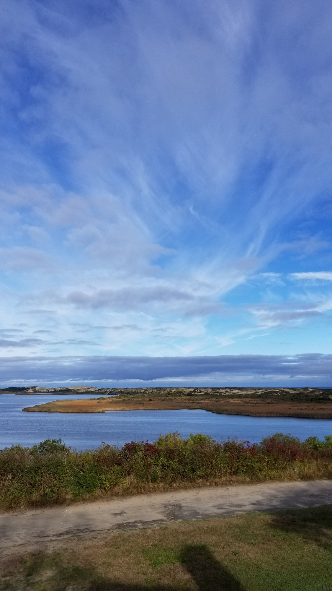 The view from High Head: Sand dunes, water , sky, and clouds in Provincetown, Massachusetts.