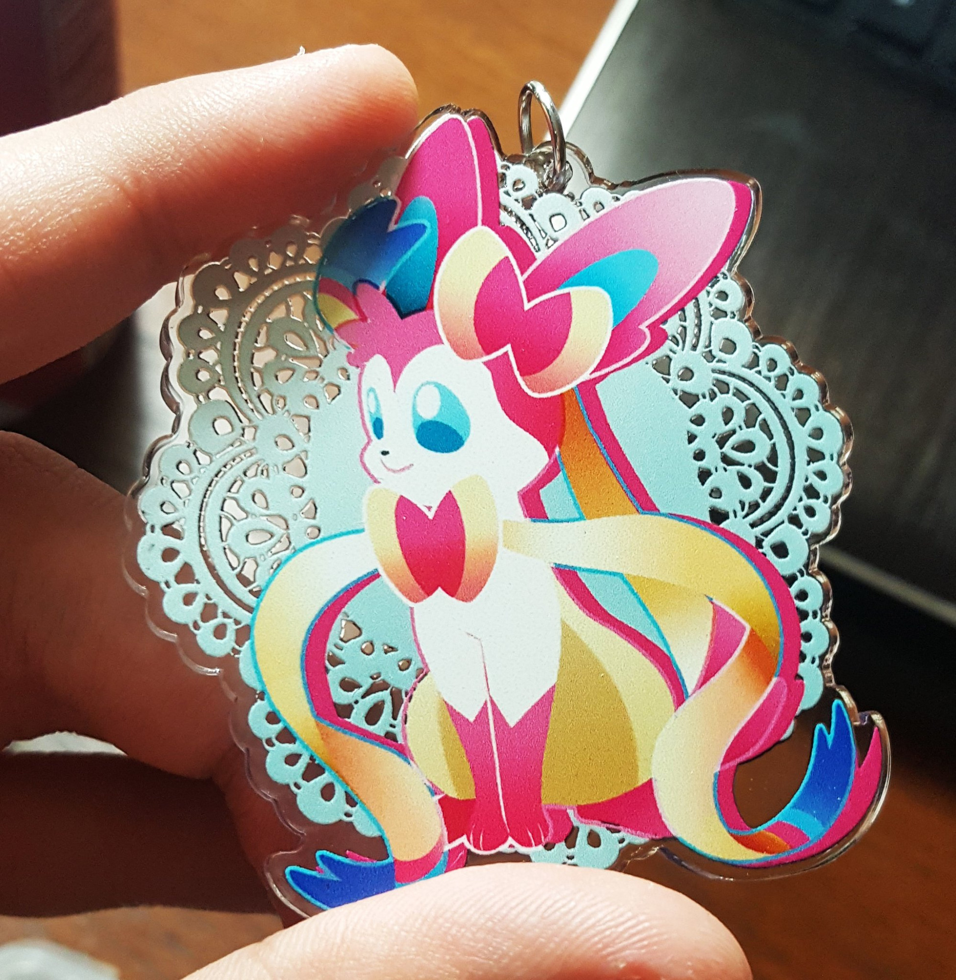 A photo of a Sylveon acrylic charm in its normal colors.