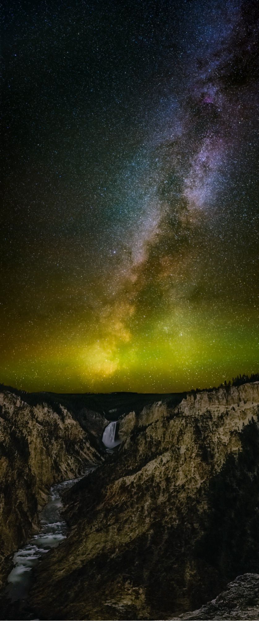 The Milky Way over Yellowstone’s famous Lower Falls. Strong airglow paints the near-horizon sky a haze of neon yellow-ish green.