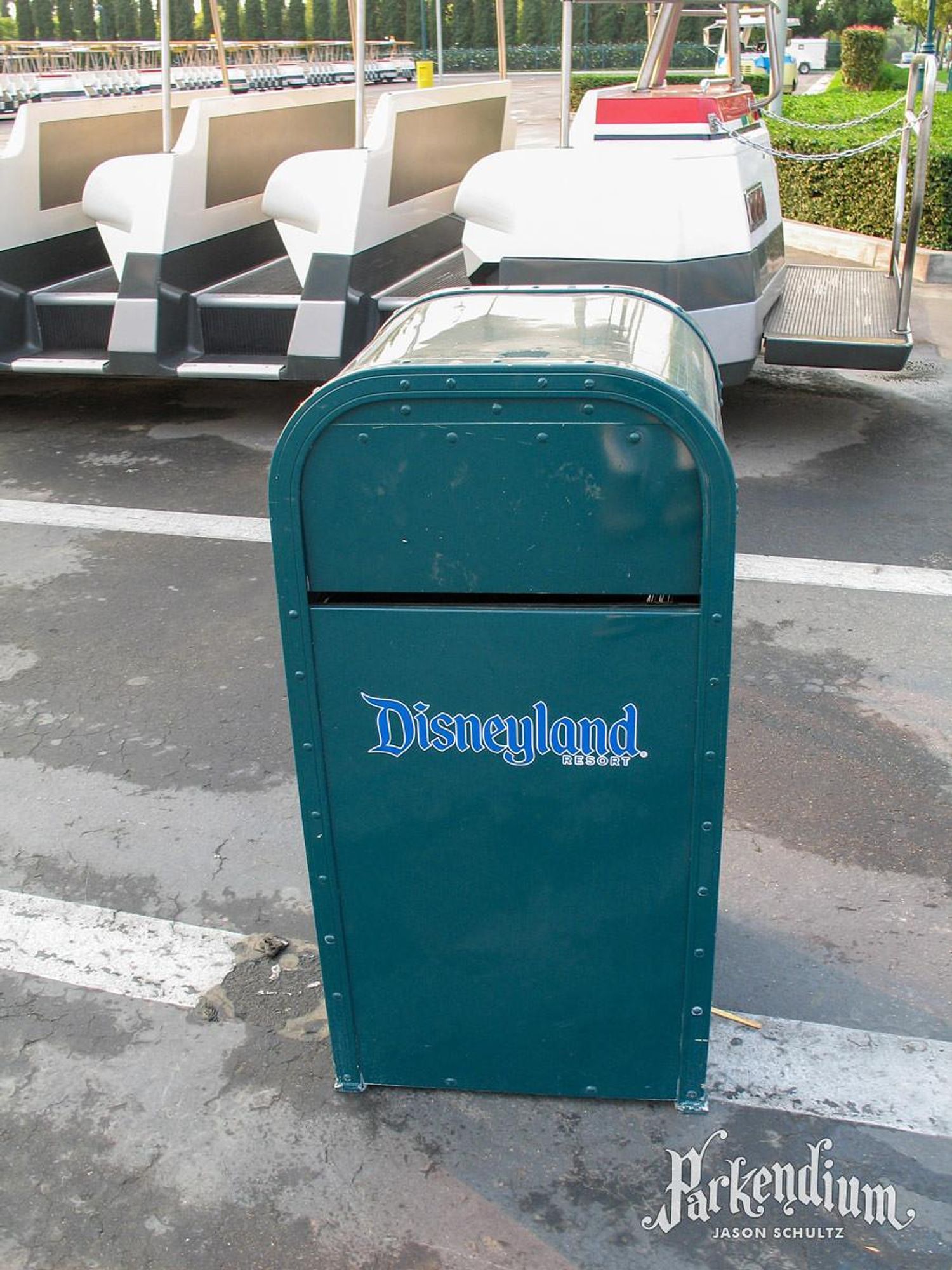  Teal green Disneyland Resort trash can sitting next to a tram 