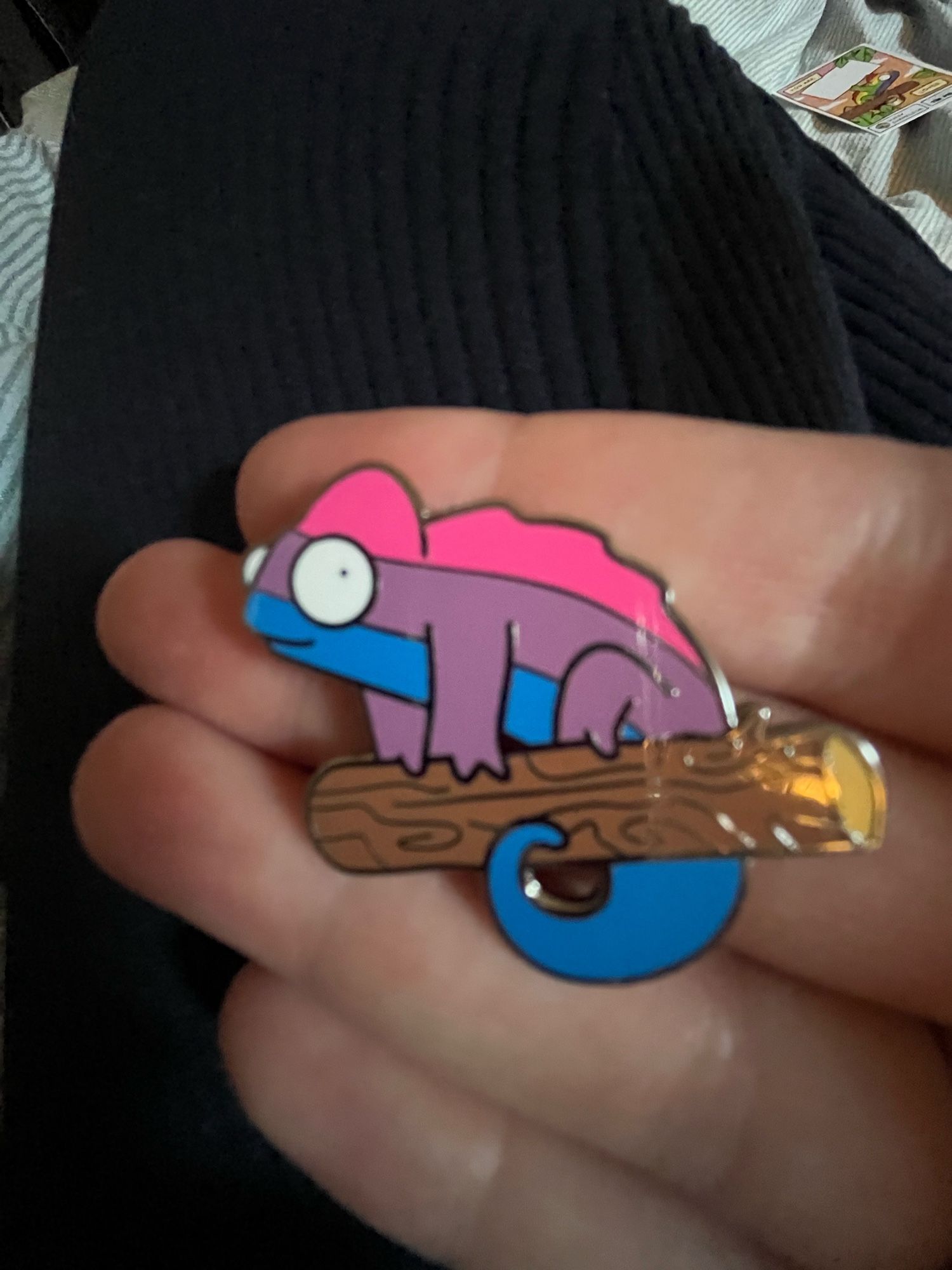 a chameleon pin in bi-pride stripes (pink, purple and blue)