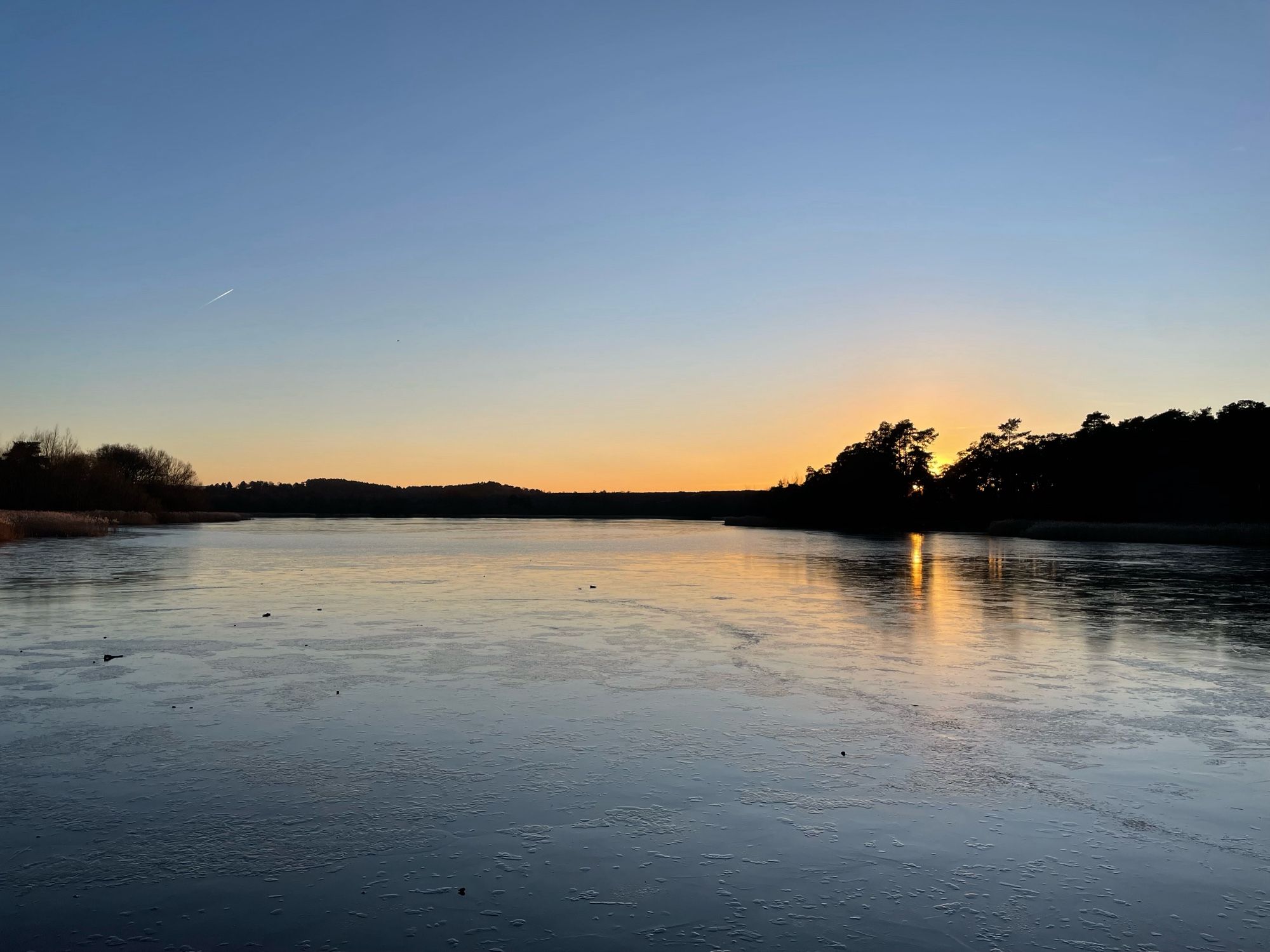 Sunset over a frozen Frensham Little Pond