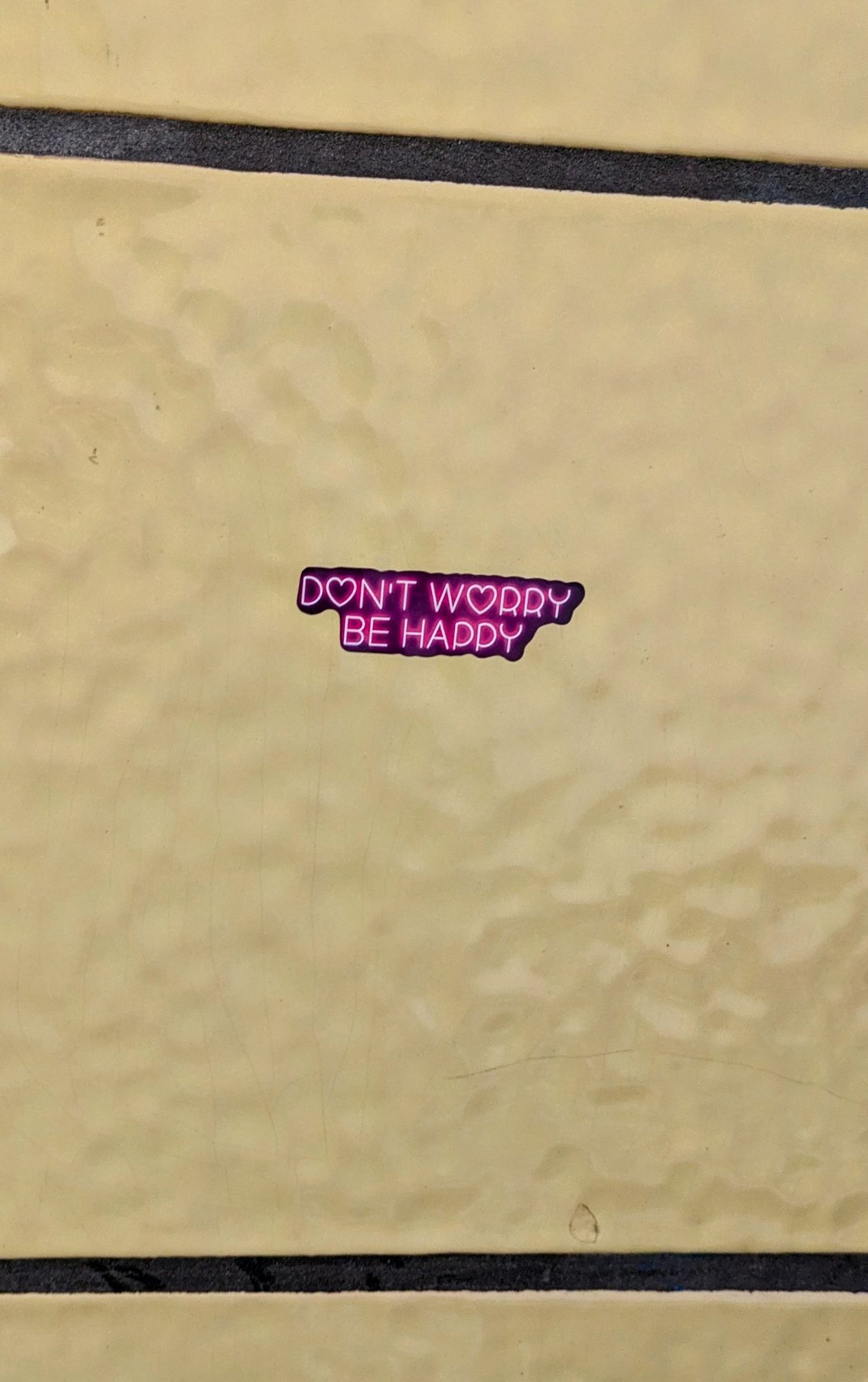 Aufkleber an gelber U-Bahn-Kachel
"Don't worry, be Happy"