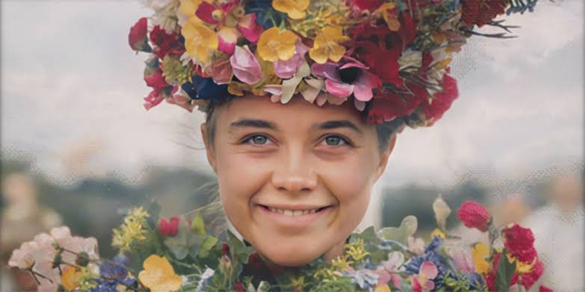 Cena final de Dani, personagem de Florence Pugh em Midsommar: O Mal Não Espera a Noite, onde ela e sua coroa estão cobertas de flores e ela mostra um sorriso largo mesmo com um olhar perdido. O fundo é claro e desfocado e ela é enquadrada dos ombros para cima.