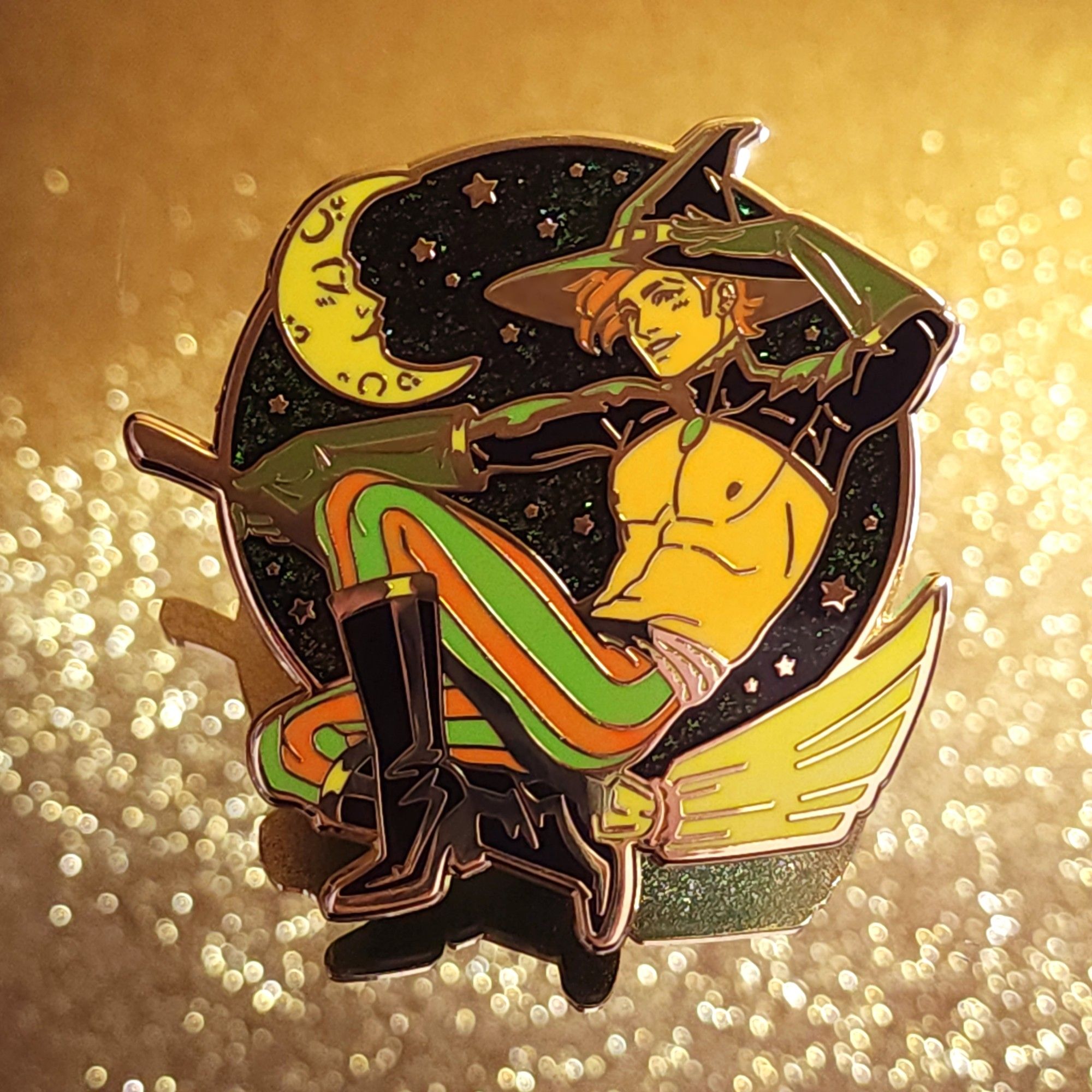 Photo of my new pin that features a handsome witch guy on a broom in front of a starry sky