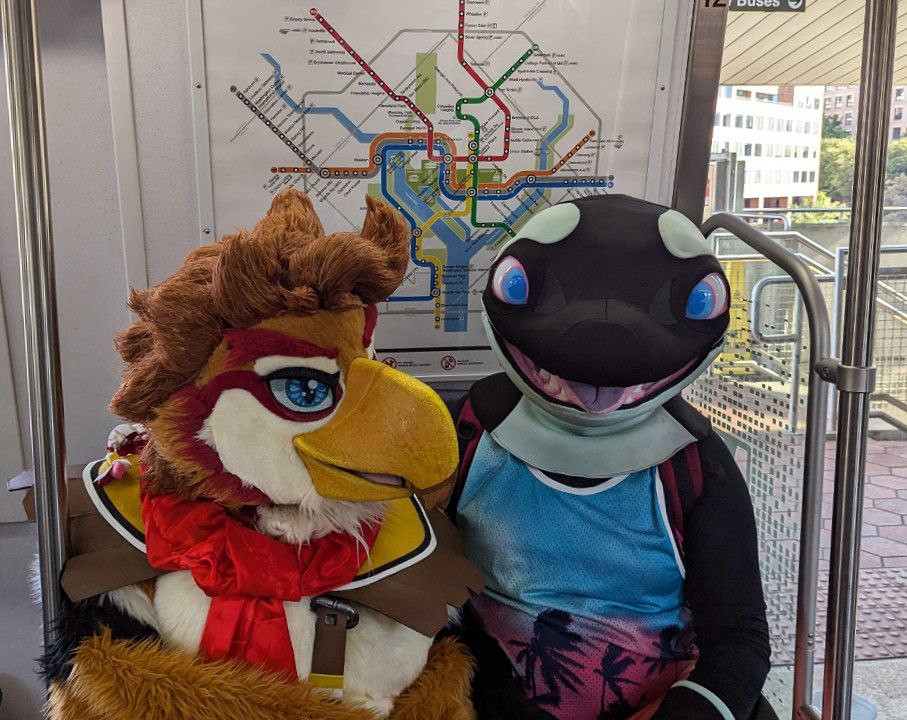 A Rito and orca fursuiter riding the metro