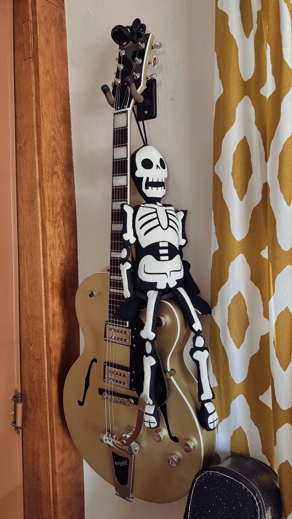 Stuffed skeleton sitting on a gold guitar