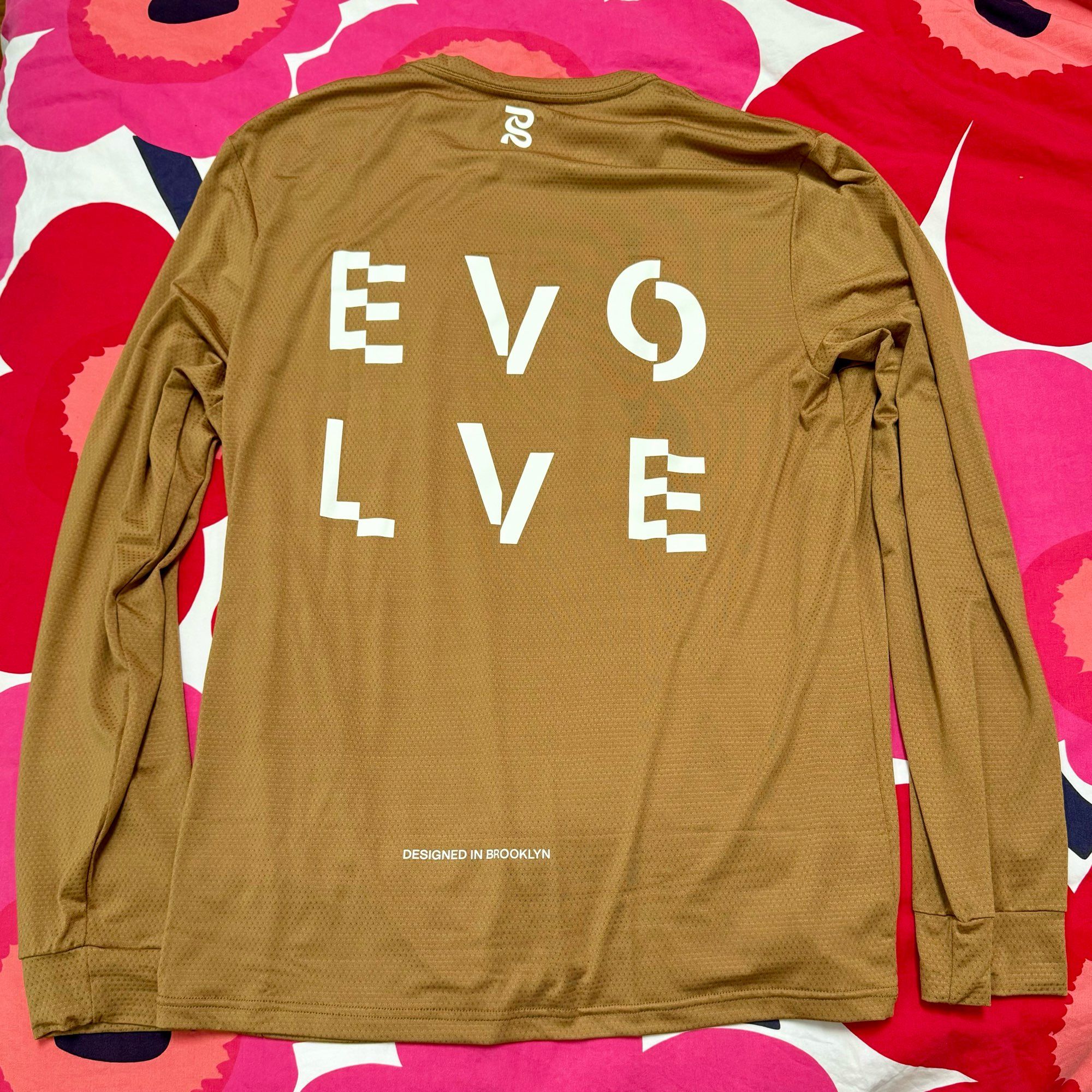 An athletic shirt layer flat reading “Evolve” in stylized script