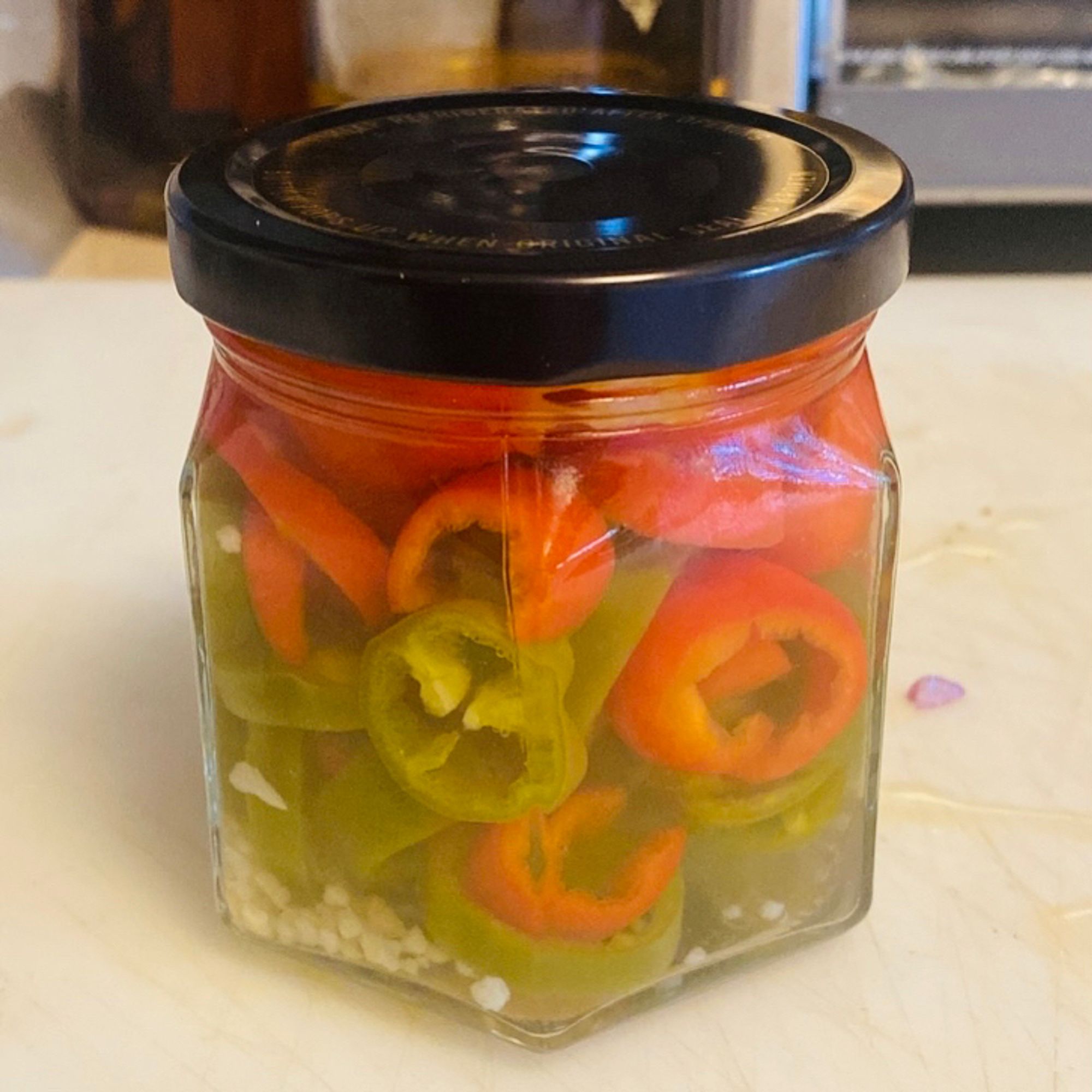 Jar of pickled jalapeños (red and green)