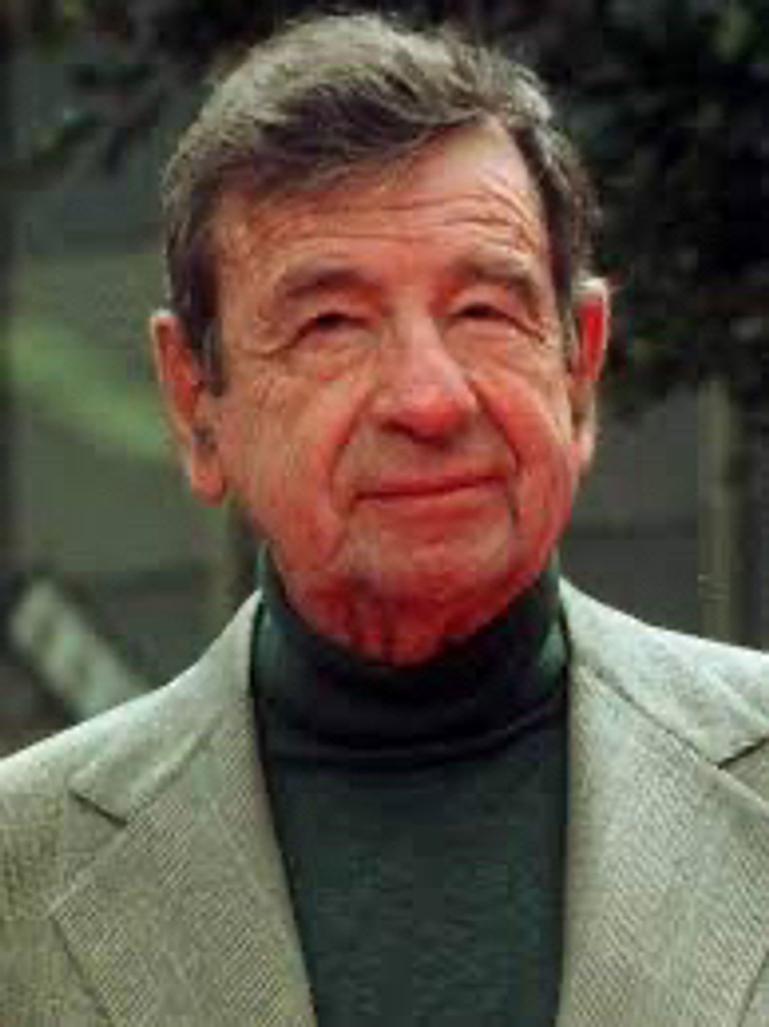 Photo of actor Walter Matthau wearing a dark turtleneck and a light colored blazer / suit jacket looking at the camera giving a neutral expression.