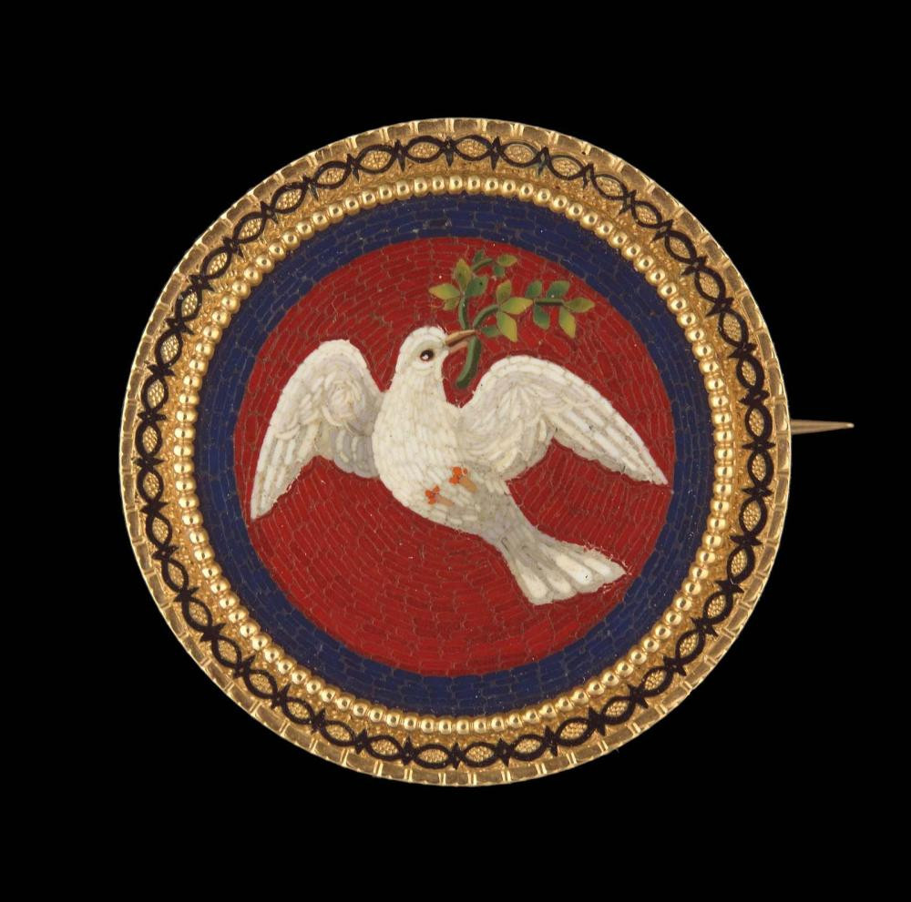 Mosaic medallion of a white dove with a green branch in its beak against a red ground bordered with dark blue. Gold and black enamel setting.