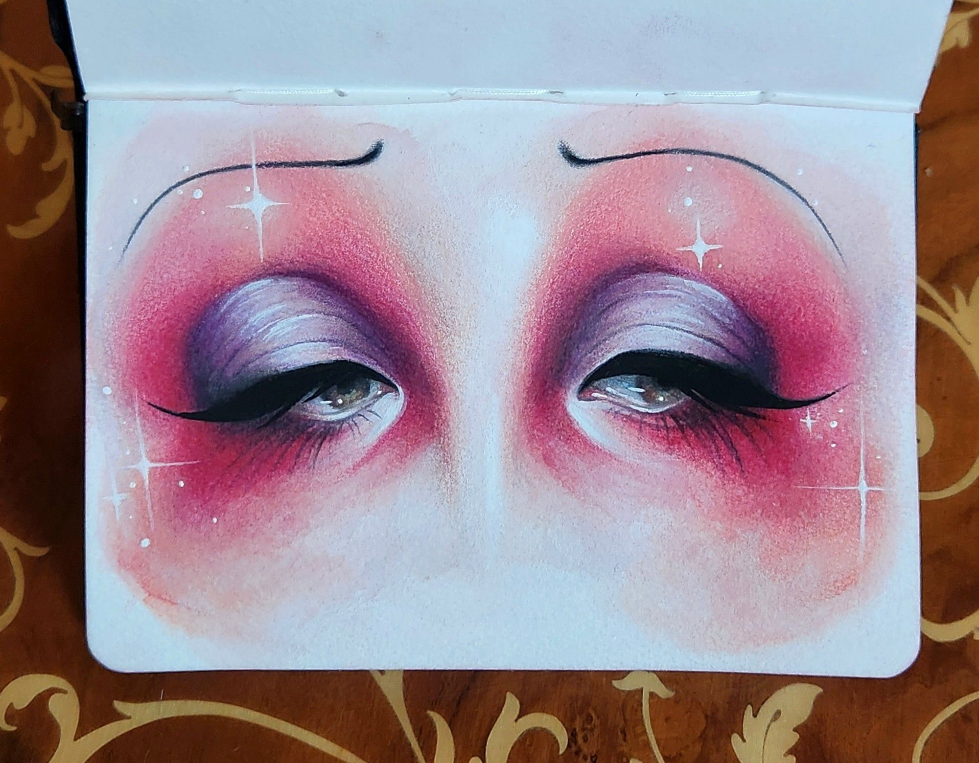 Painting of a woman's eyes wearing bright pink and mauve eye shadow softly blended across the page. She has pencil thin sad eyebrows and thick black liner and lashes painted in a droopy puppy dog sort of look. There's a few white sparkles around the sides
Painted in watercolor, gouache, and colored pencils