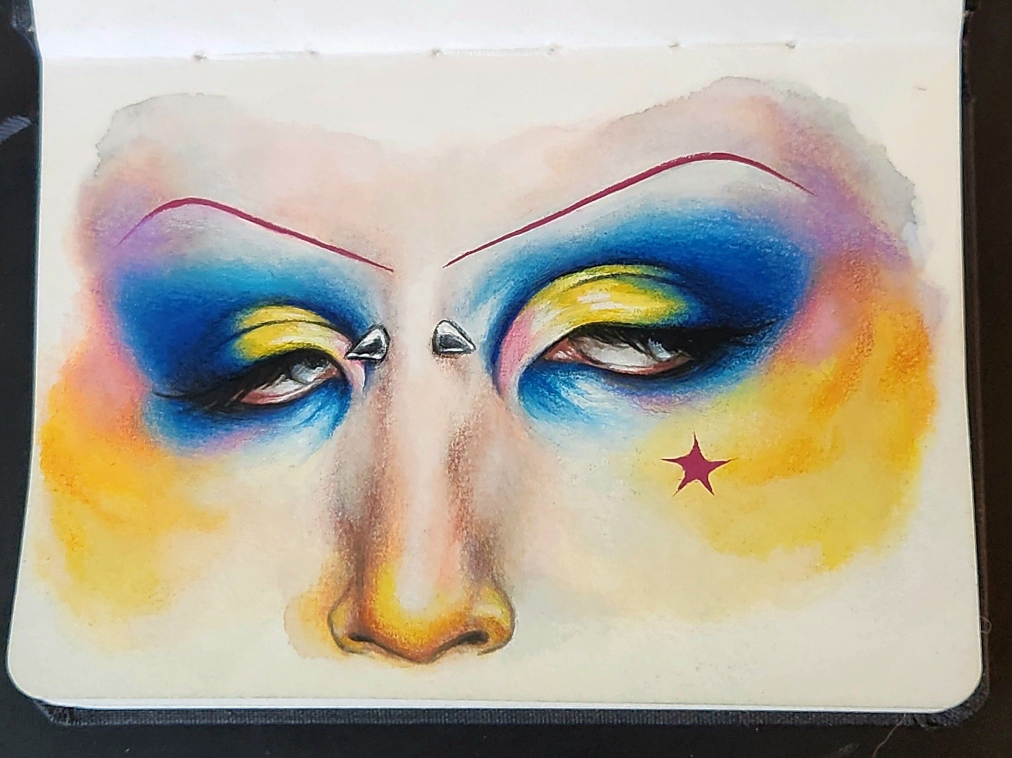 Painting of a person's eyes and nose and they have a cut crease eye look consisting of electric blue, yellow, and pink. The rest of the skin is blushed in yellow and pink hues. They have a piercing on their nose bridge and a little red star on their cheekbone
Made with watercolor, gouache, and colored pencil