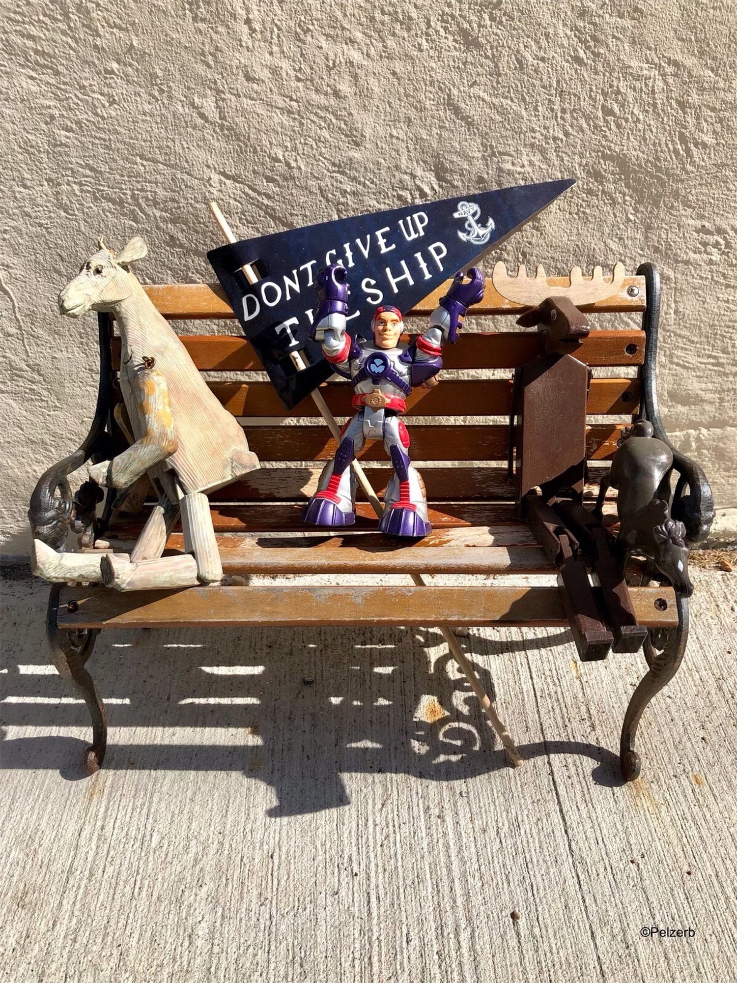 Miniature bench containing several small toys. East St., Annapolis, MD, USA. 07/06/24.