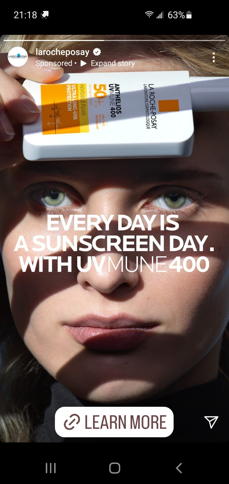 A screengrab of an instagram ad for sunscreen, with the female model holding the bottle against her forehead.