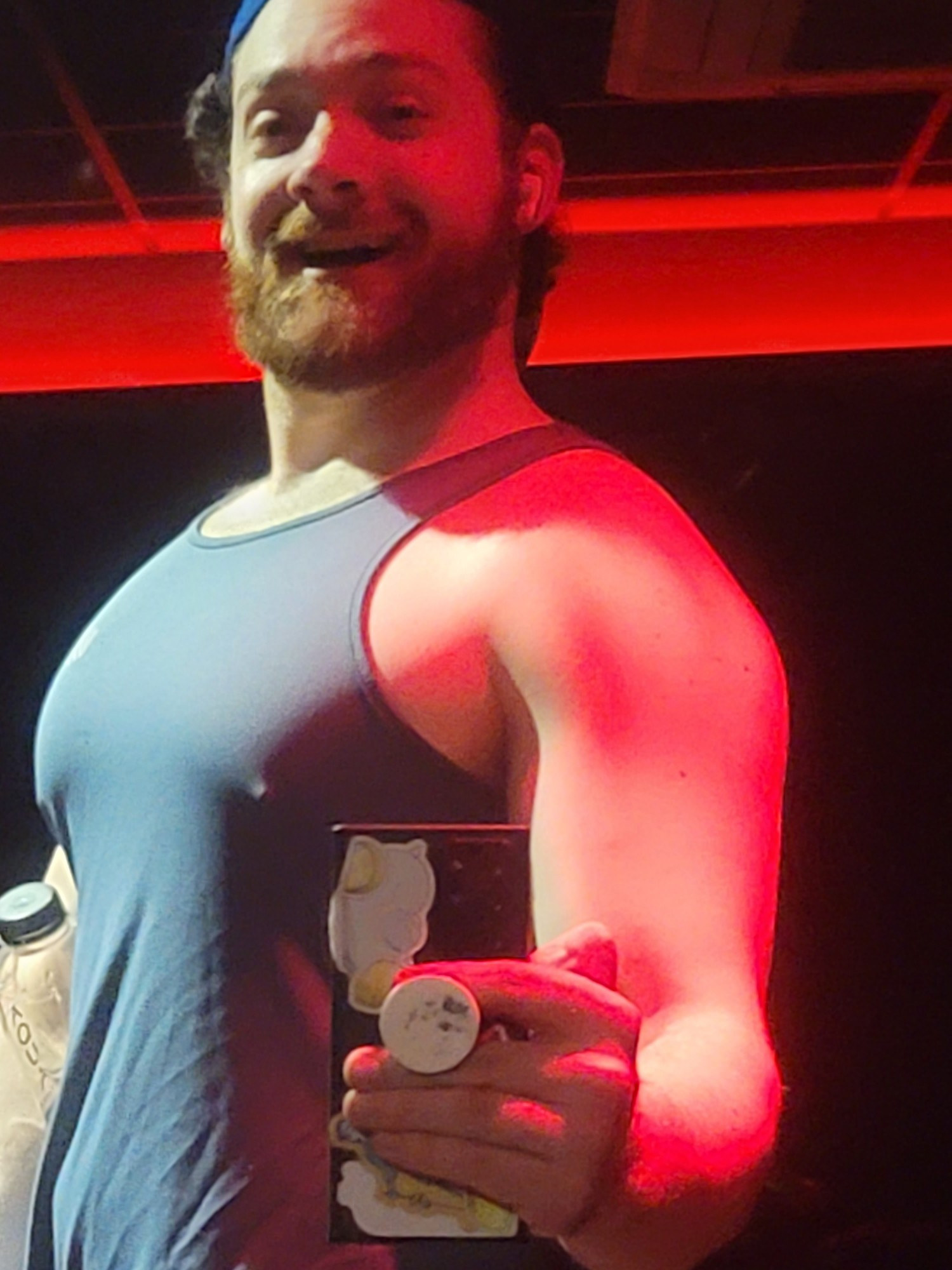 Me smiling and staring at my tits. Nips are poking through my tanktop, and the lighting is complementary