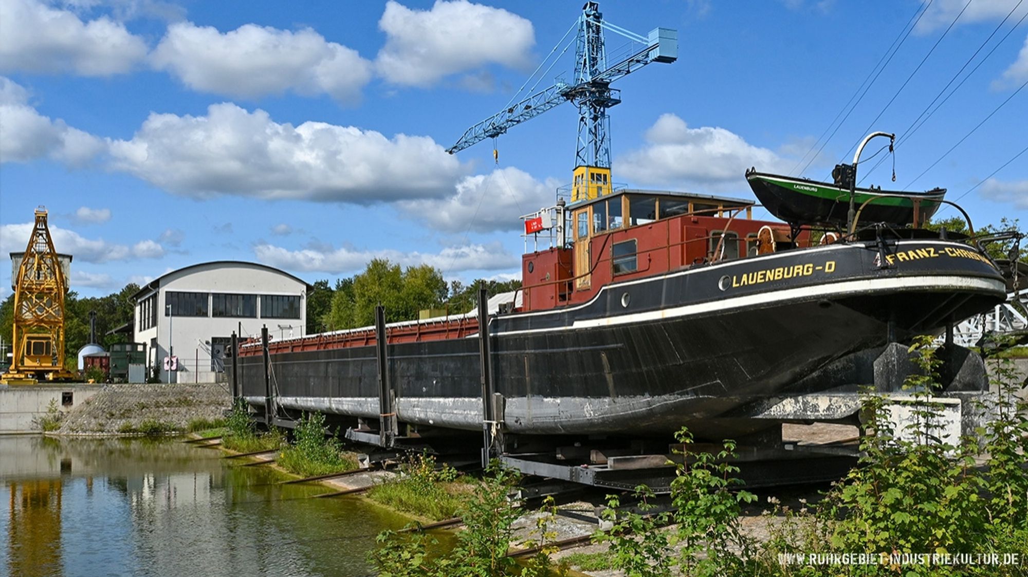 Ein Schiff auf einer Hellinganlage an einem Hafen.