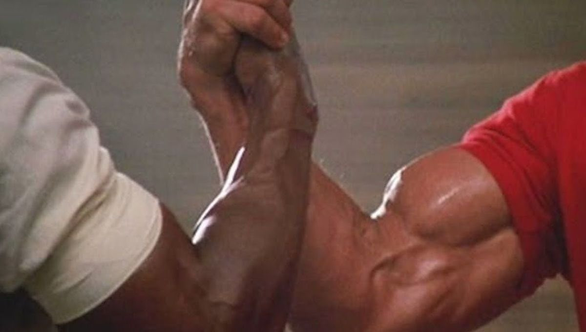 Carl Weathers and Arnold Schwarzenegger shaking hands and being all muscle in PRedator