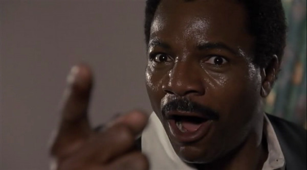 Carl Weathers from Action Jackson pointing at the camera and being sweaty.