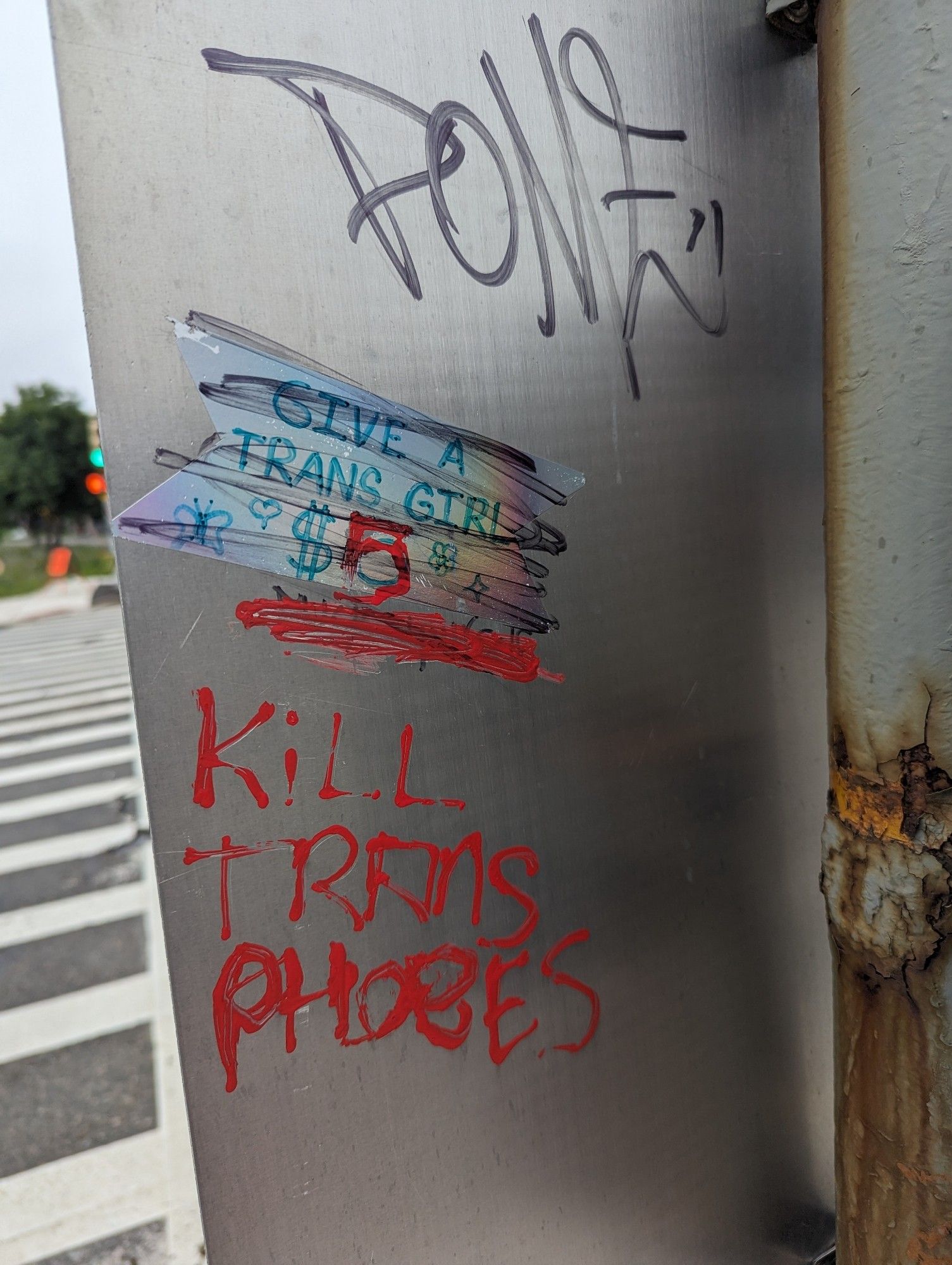 Graffiti on a pole that says to give trans girls $5