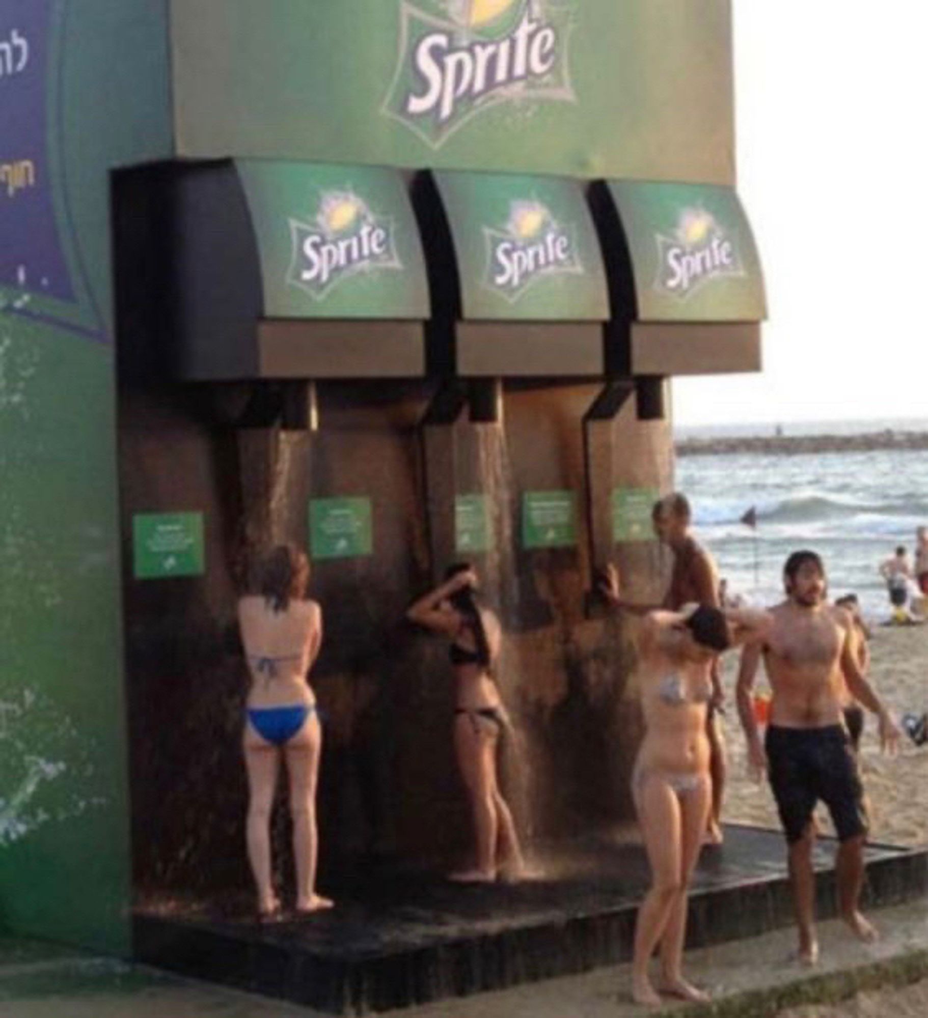 Sprite soda dispenser that is huge and people using it as a shower