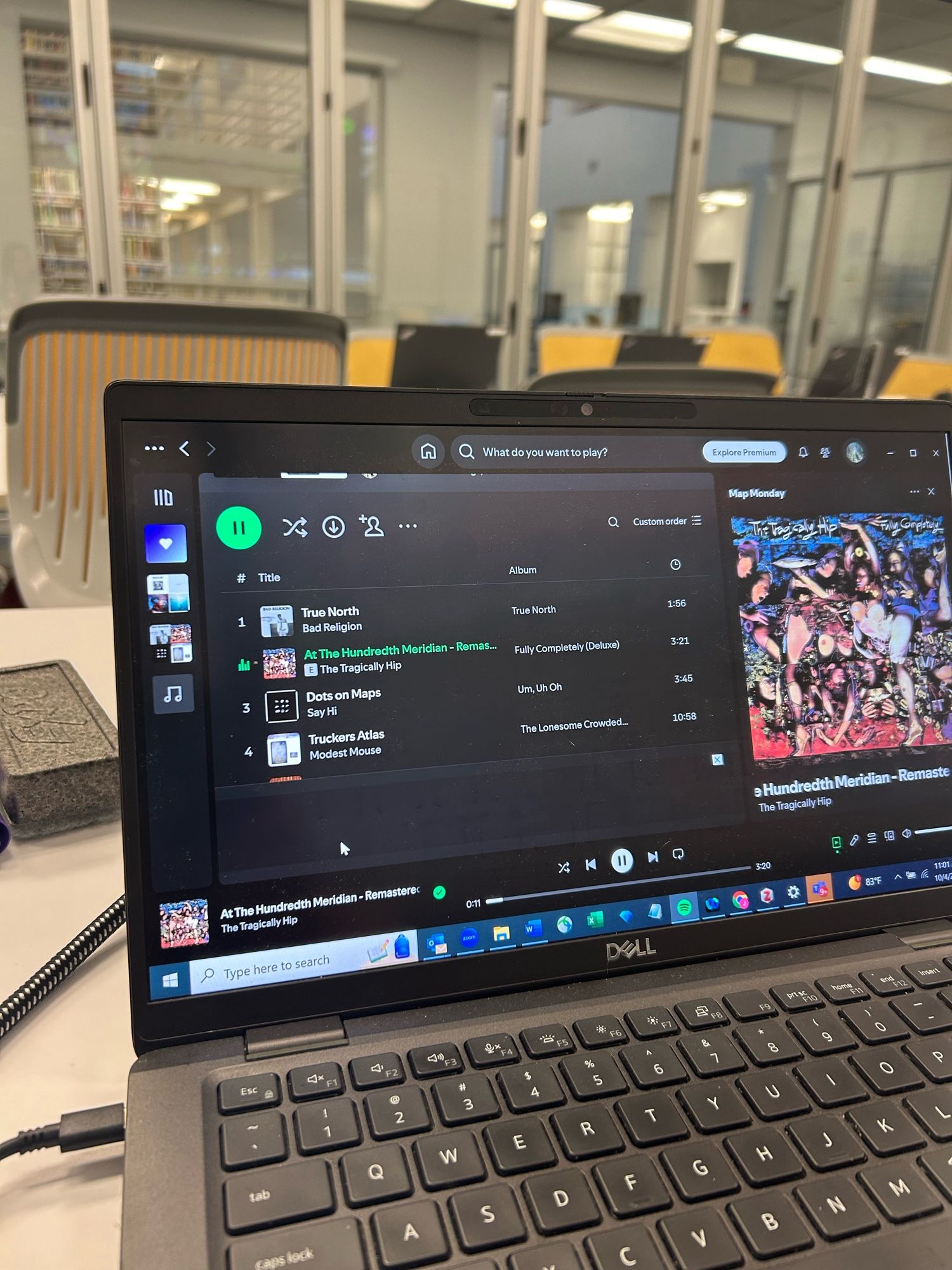 Photo of a laptop in a library classroom showing a Spotify playlist with map-themed songs.