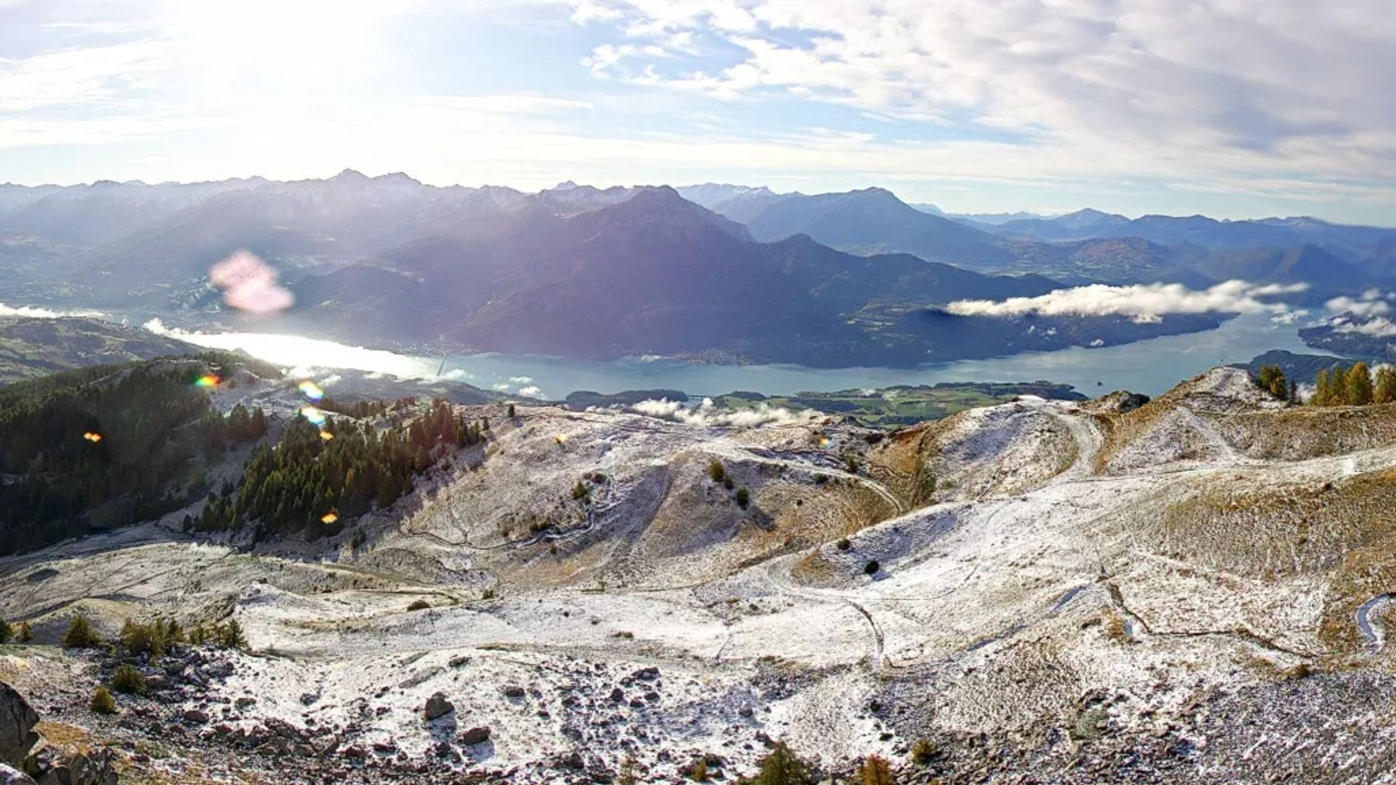 Le Lac de Serre-Ponçon, sur lequel flottent quelques nuages, et les pentes saupoudrées de neige.