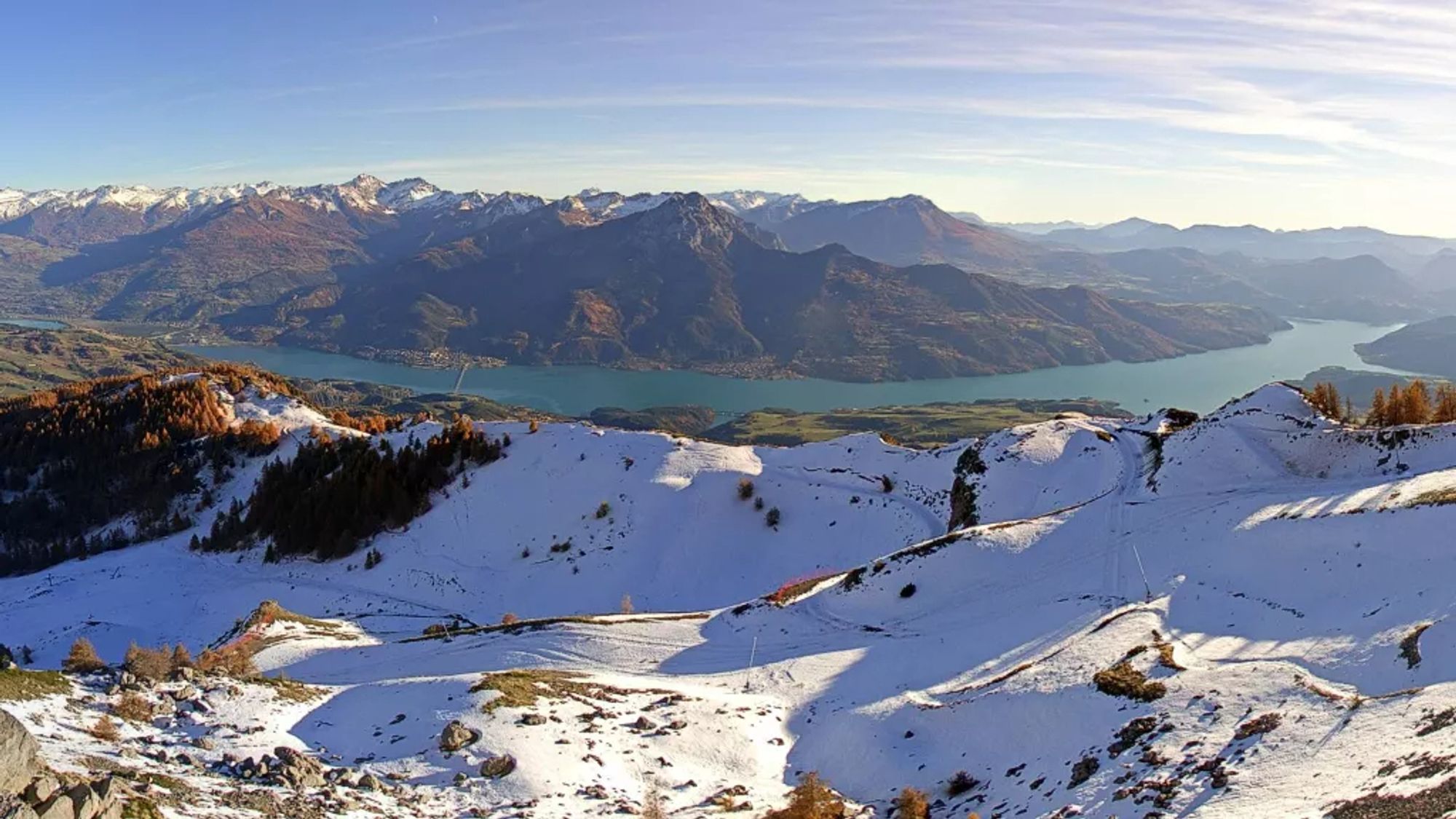 Lac de Serre-Ponçon, avec au premier plan les pentes enneigées de la station de ski de Réallon.