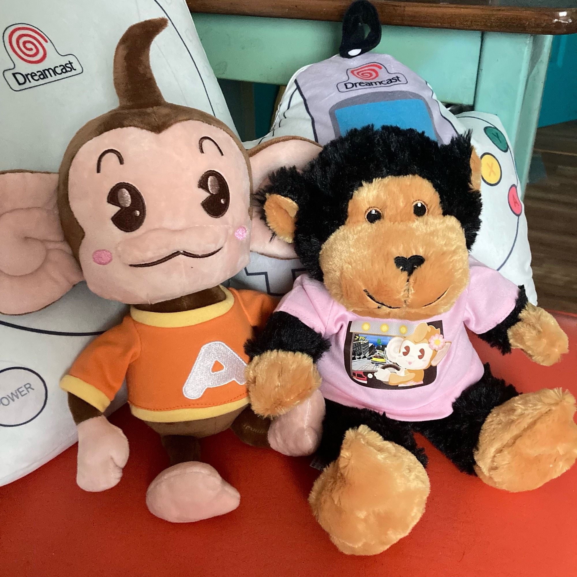 a plushie AiAi and a monkey plushie wearing the pink arcade adventure shirt