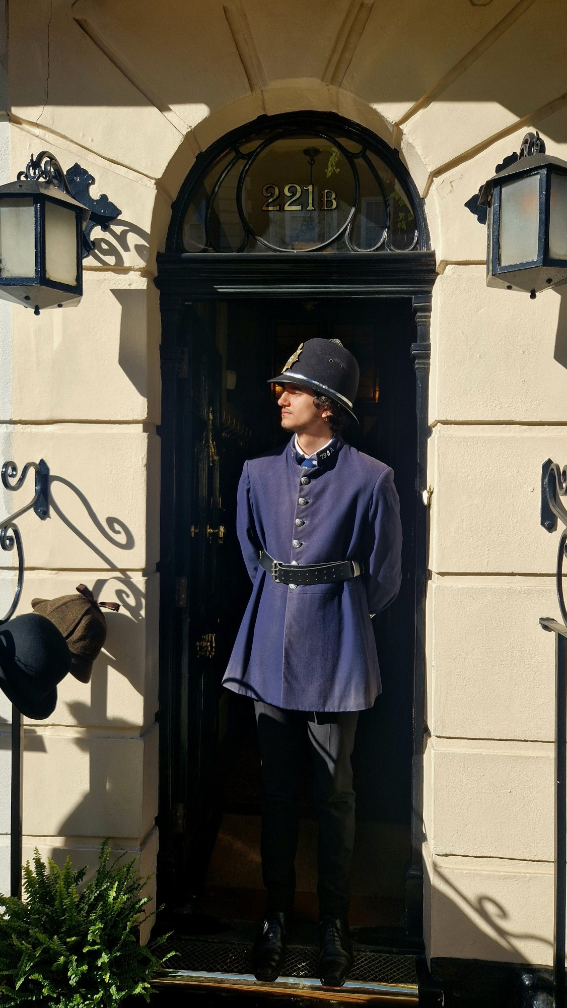 A man dressed as a victorian policeman stood outside 221B Baker Street, London.