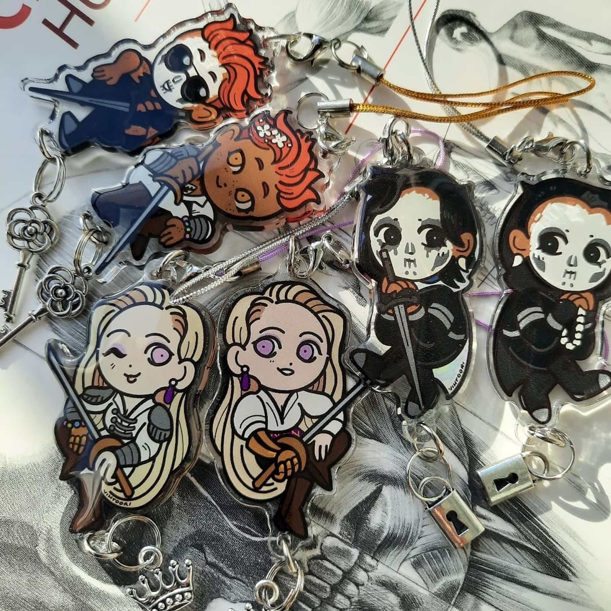 Double sided acrylic charms of characters from The Locked Tomb series.