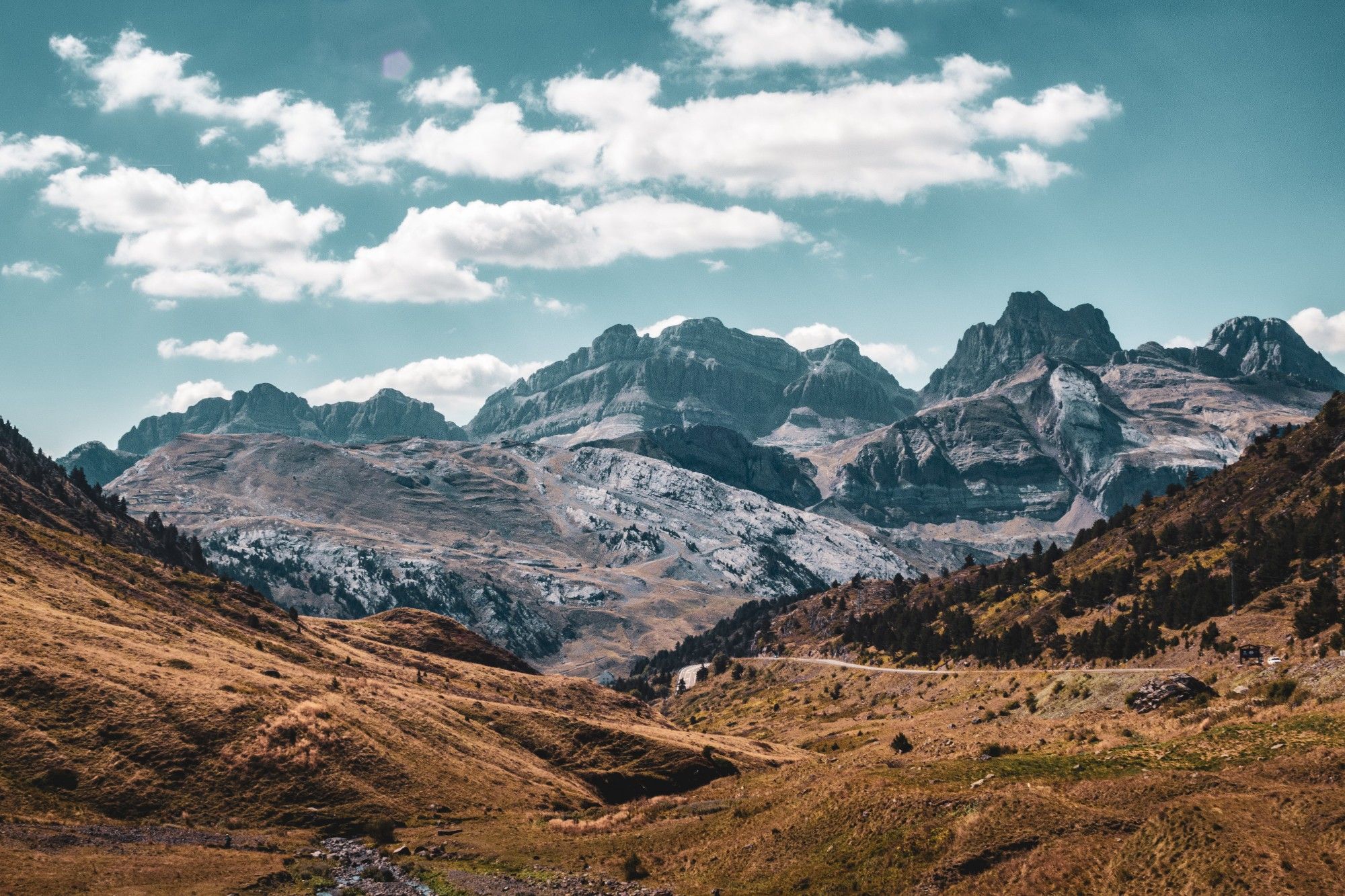 Vista de paisaje montañoso de la zona de Candanchú y Somport sin nieve y con bastante sol además de algunas nubes.