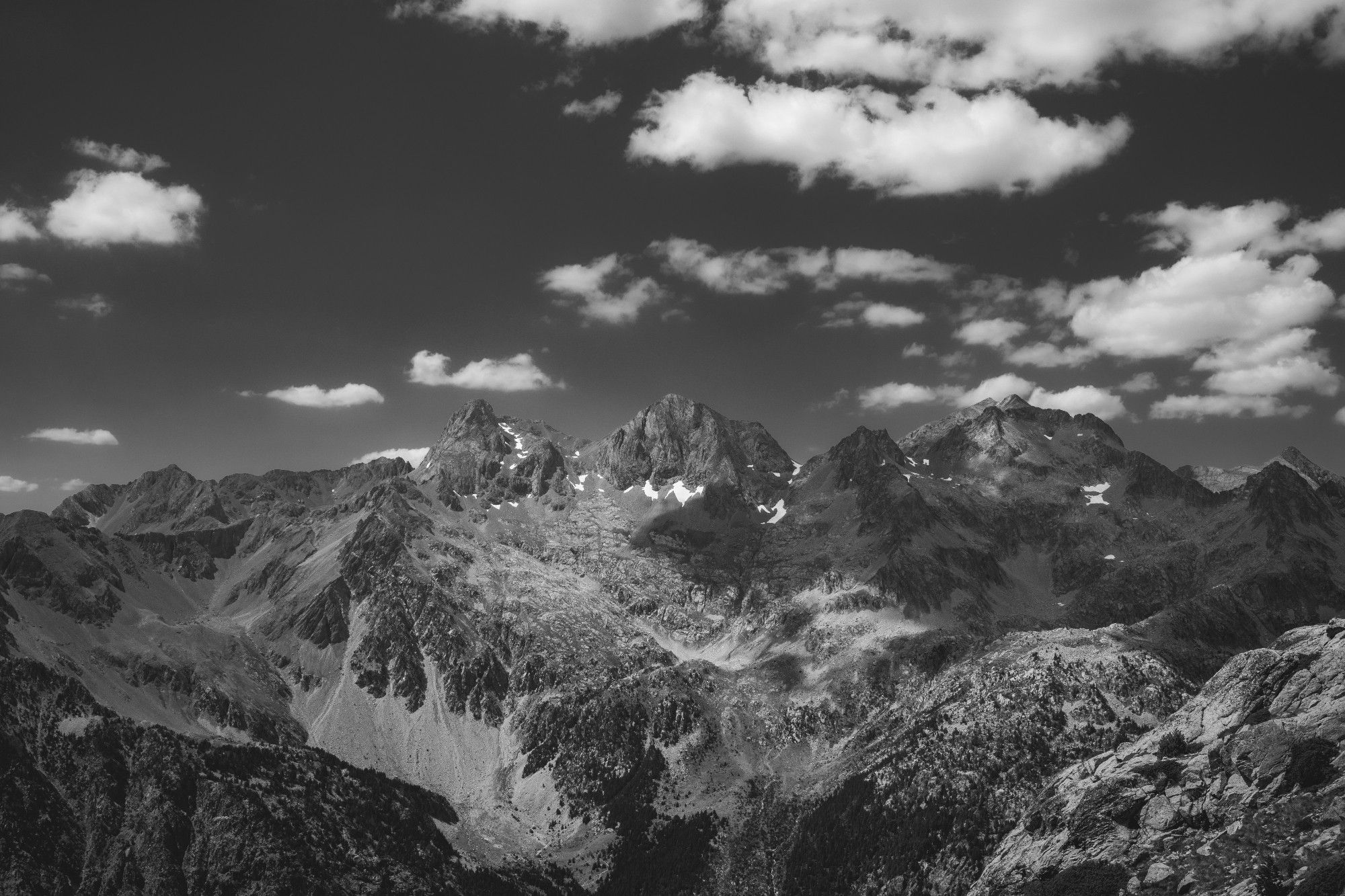 Fotografía en Blanco y negro de parte de una cordillera de montañas (entre ellas está el pico Garmo Negro) vistas desde la zona de llegada al ibón de Brazatos.