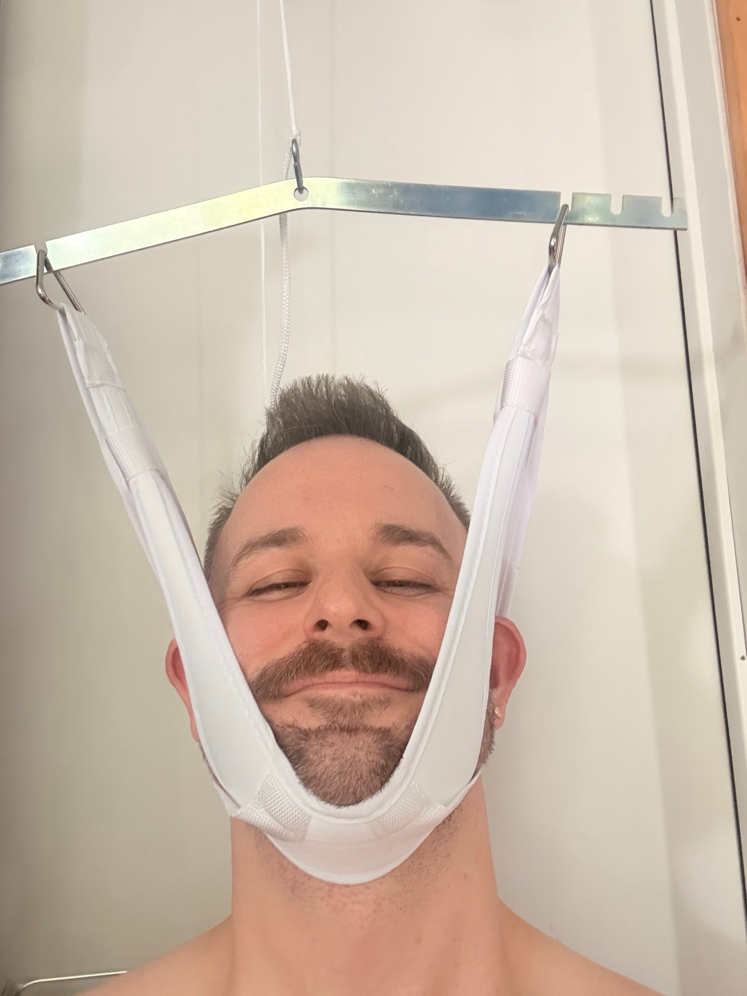 My smiling head in a cervical traction device. It helps with my nerve compression issues in my neck and shoulder