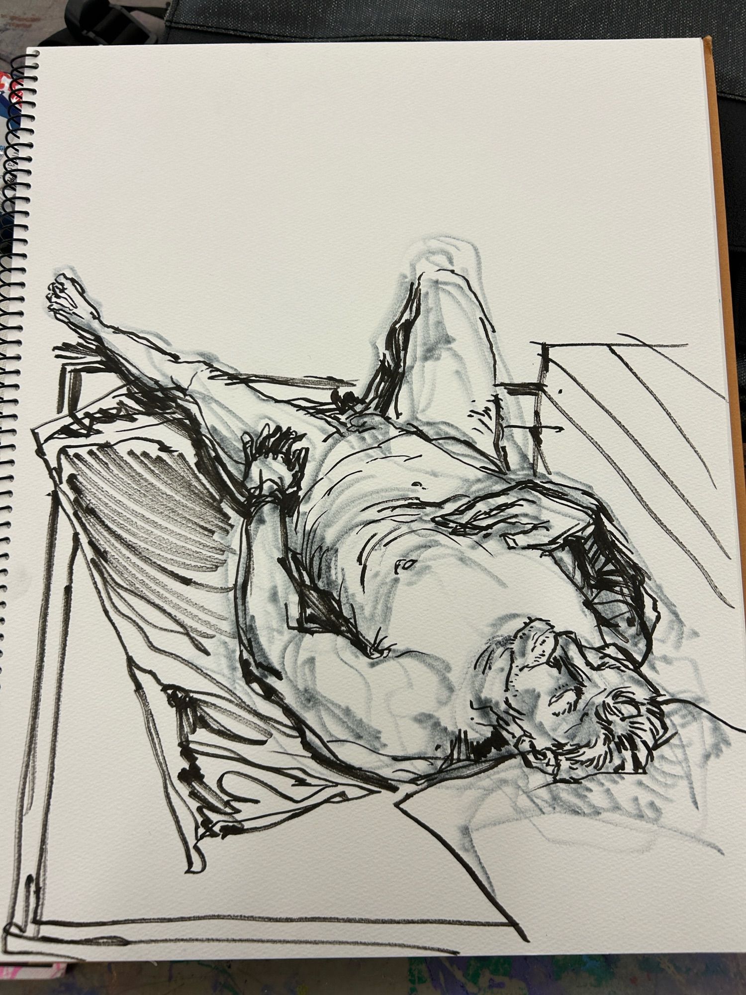 A black marker sketch of a nude man reclining