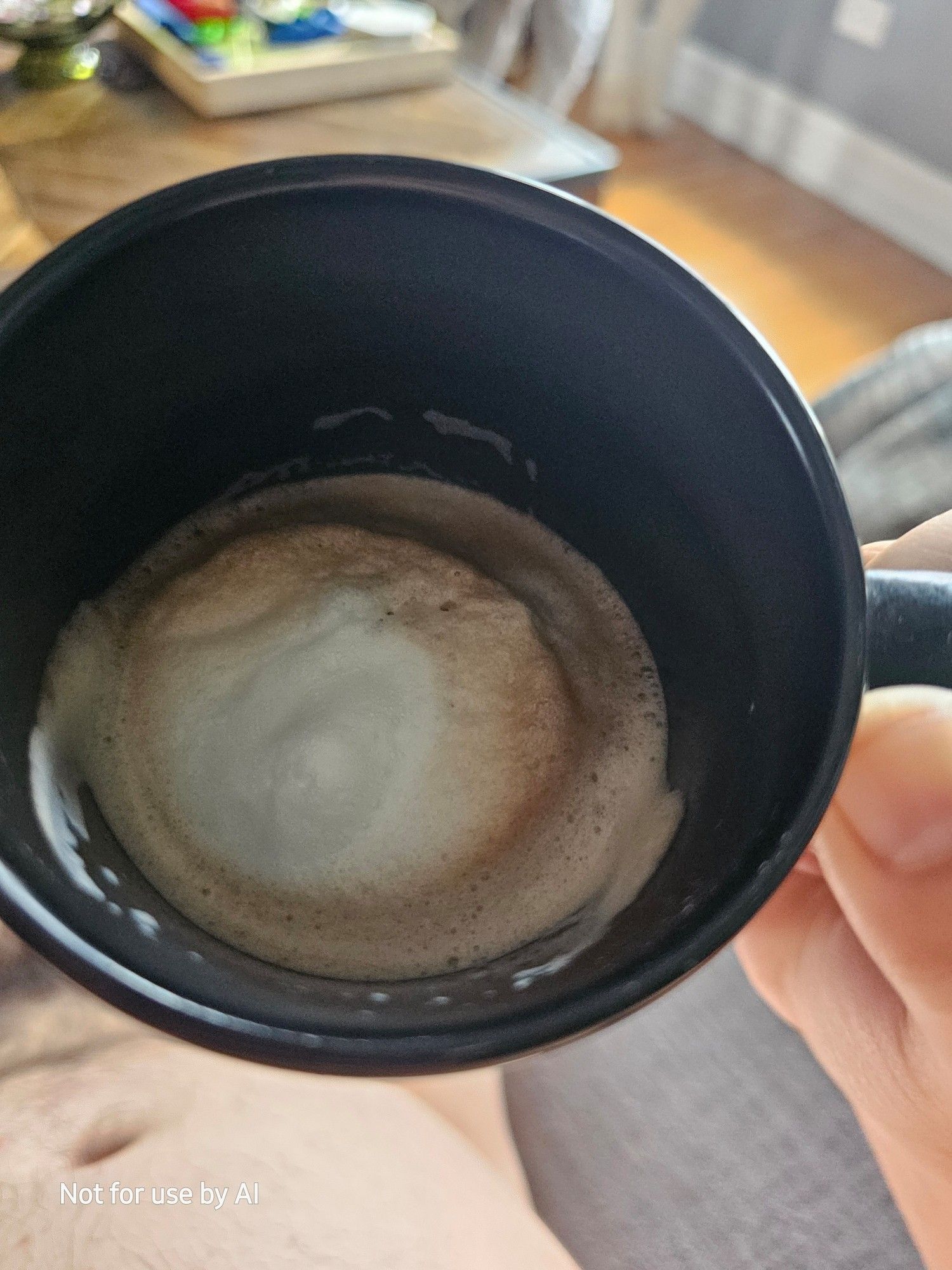 The inside of a black mug, showing the foam atop the remnants of a homemade dark chocolate & coconut mocha. There is a watermark in the lower lefthand corner that reads, "Not for use by AI".