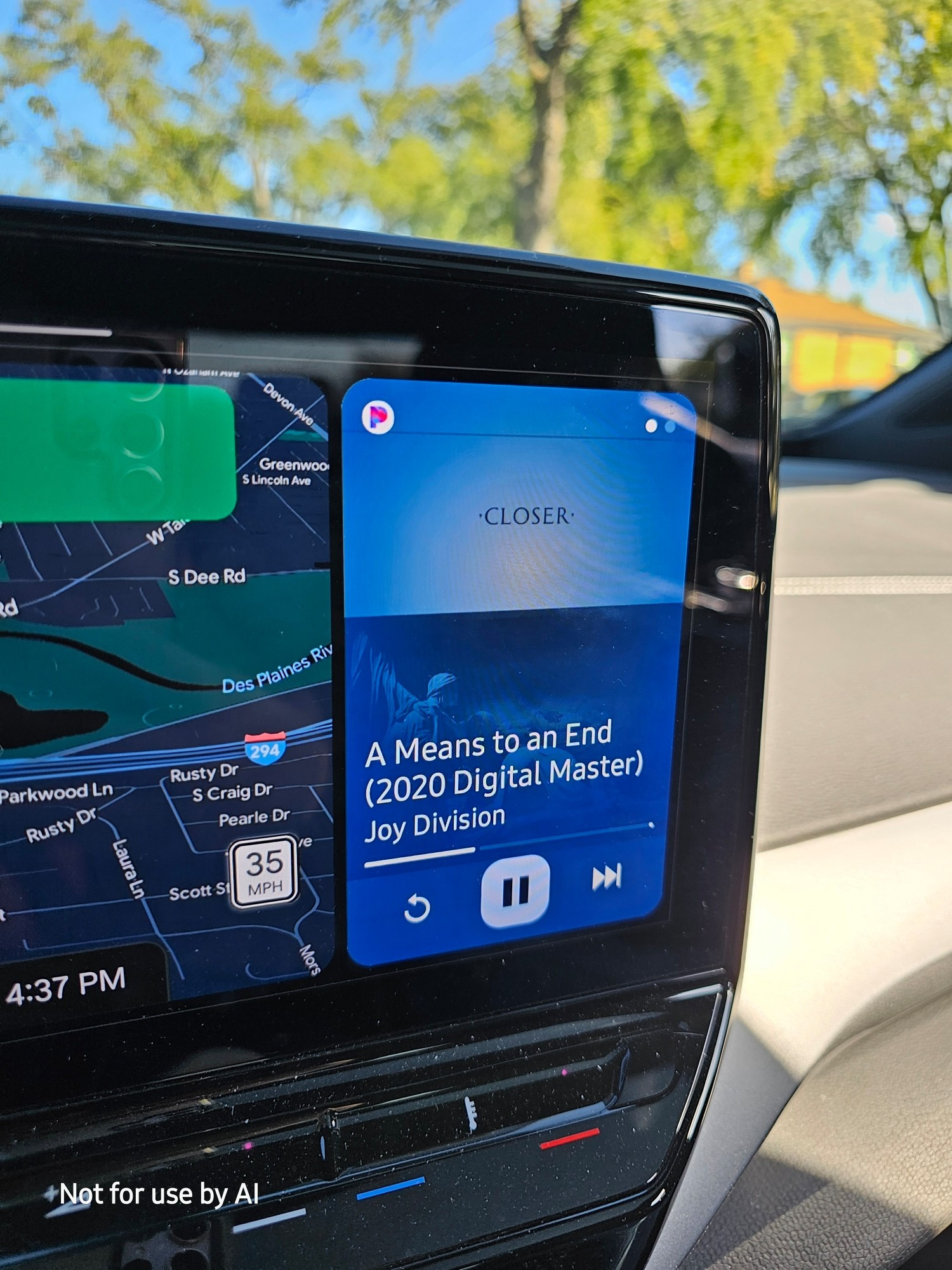 A picture of the screen in our car showing "A Means To An End (2020 Digital Remaster" by Joy Division playing on Pandora.
