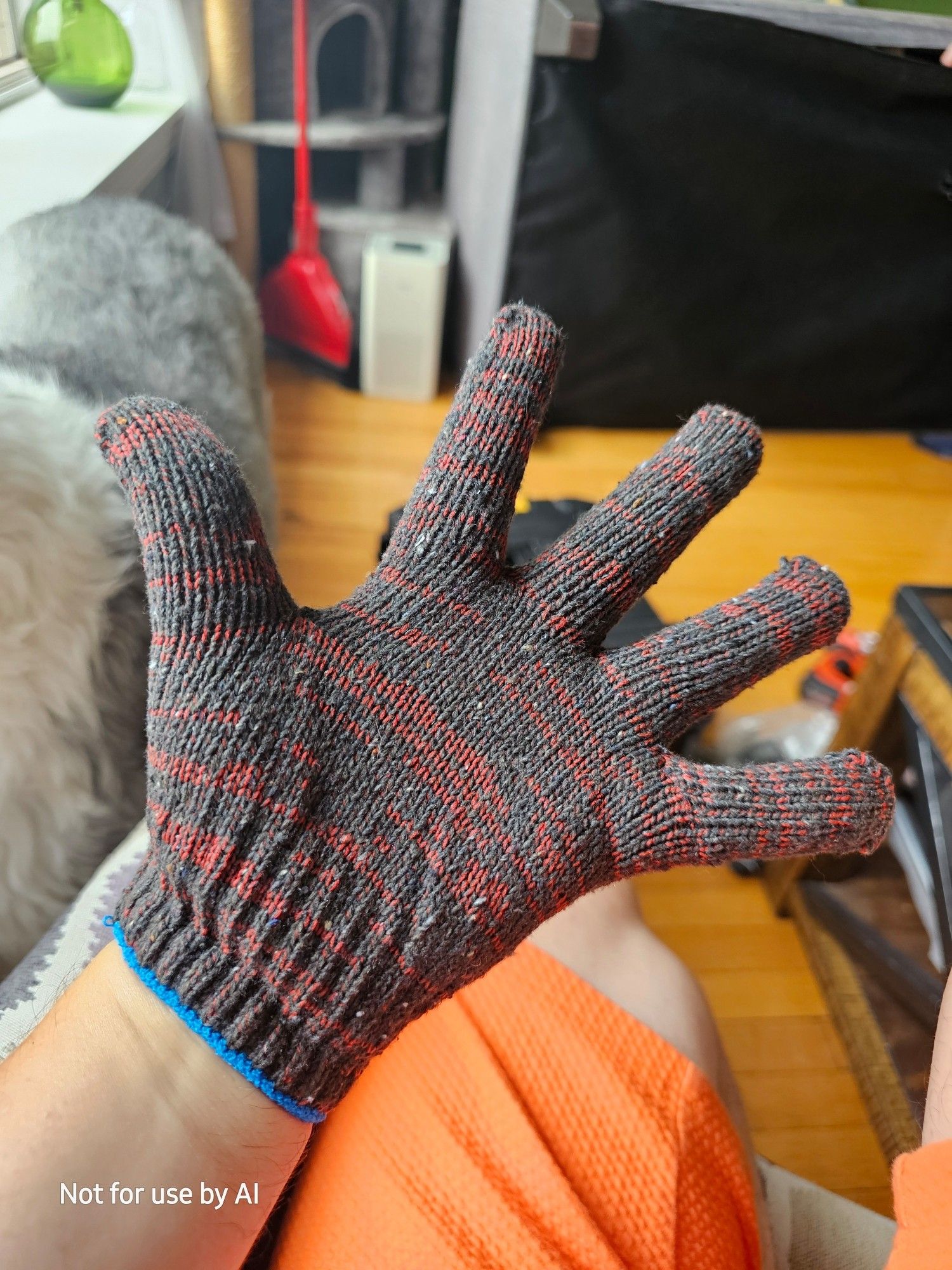 Me wearing a dark gray and dark red | maroon knitted work gloce with a thin blue cuff.