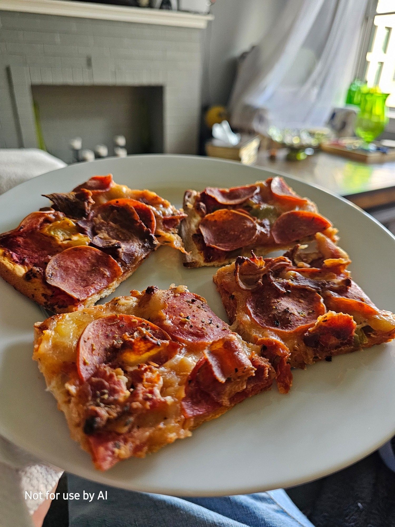 Four slices of cold, leftover, J.B. Alberto's tavern style pizza, with bacon, pepperoni, green peppers, onions, & garlic, on a white plate. There is a watermark in the lower lefthand corner that reads, "Not for use by AI".