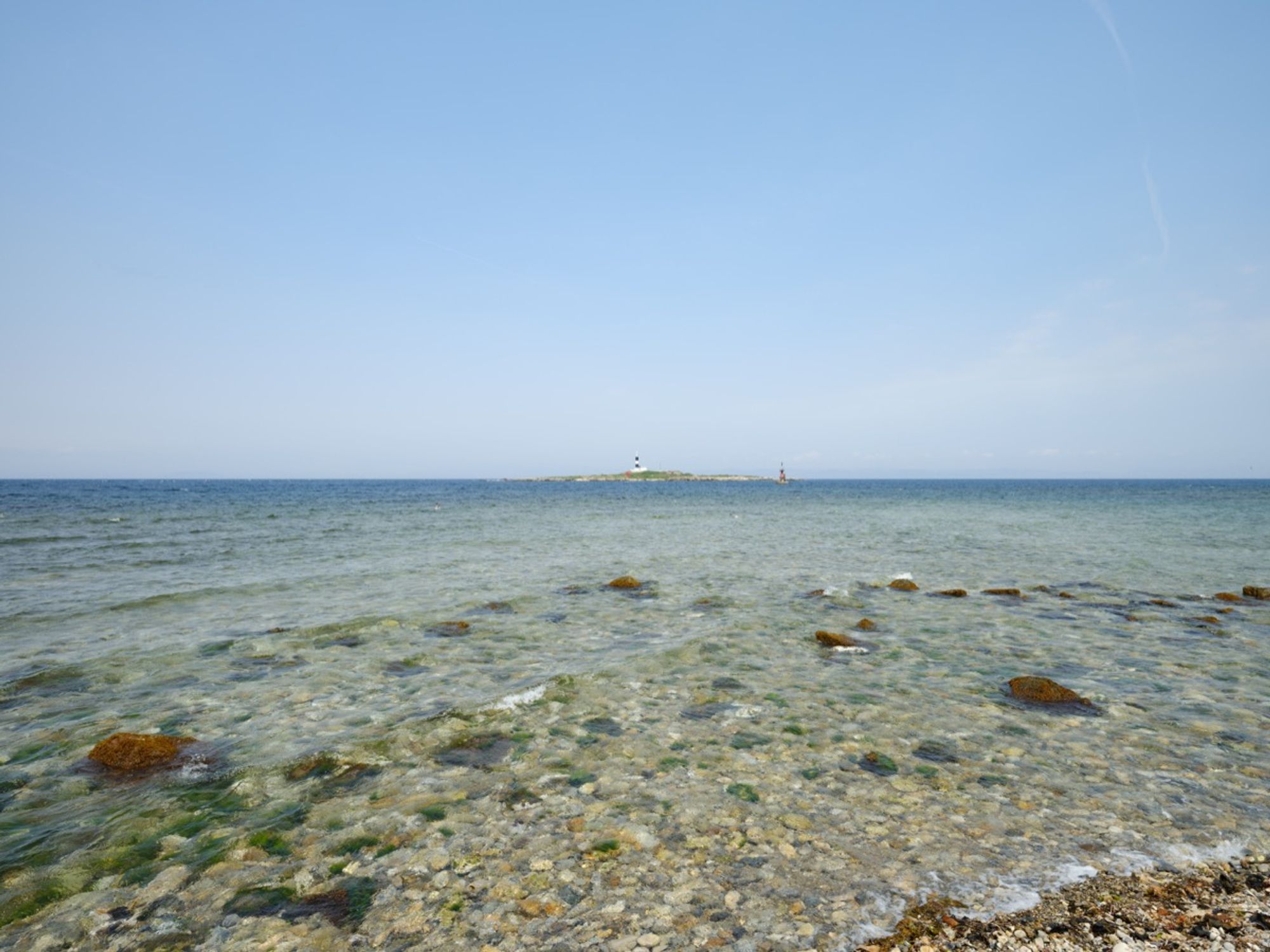 Hokkaido can be seen beyond the lighthouse and the horizon. The island with the lighthouse in the center is called Bentenjima, which also has a shrine if you look closely. Captured in 2024 with the GFX100S and GF23mmF4 R LM WR. Aomori, Japan.